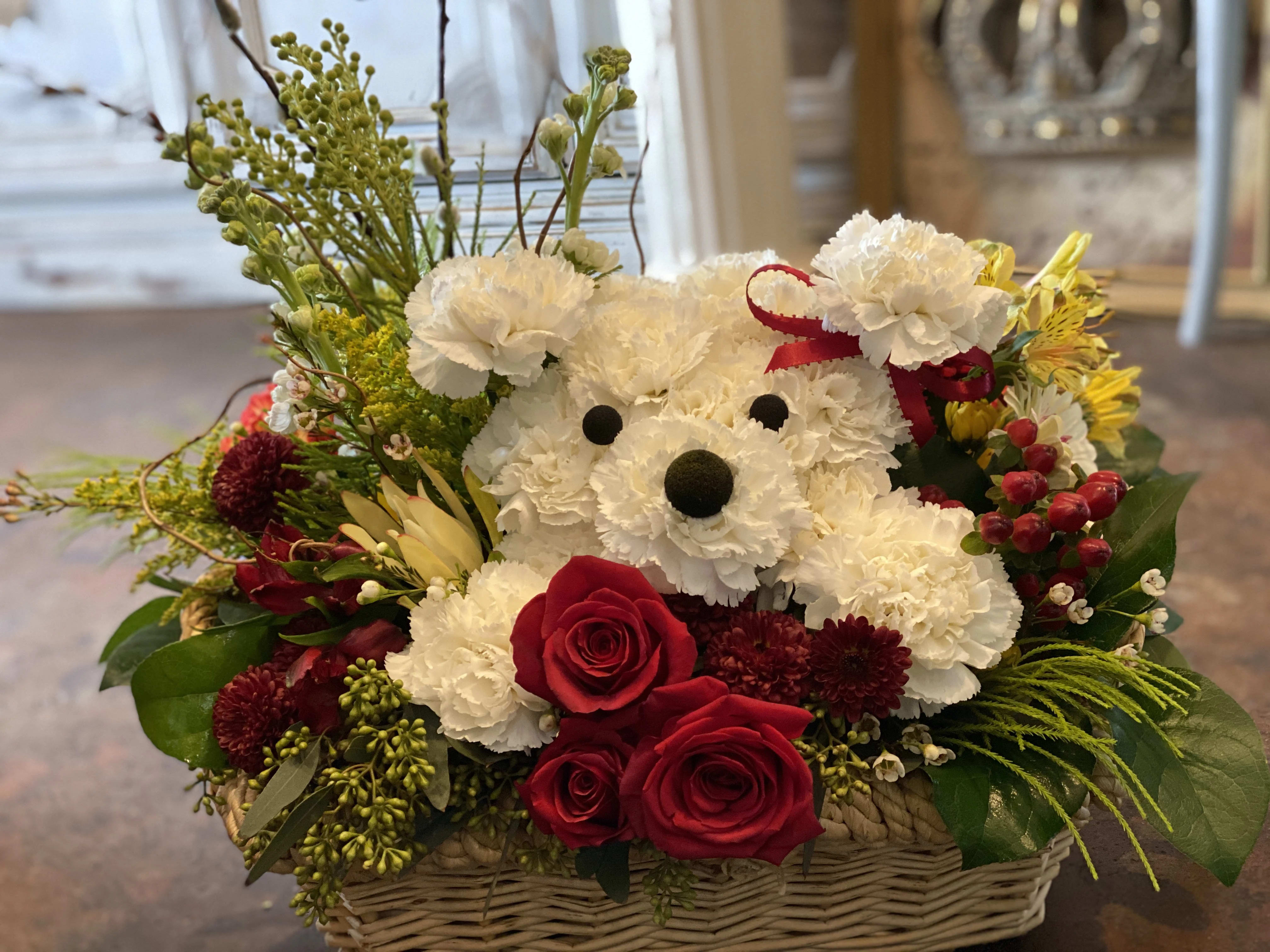 Basket arrangement with a teddy bear made of white carnations and red roses