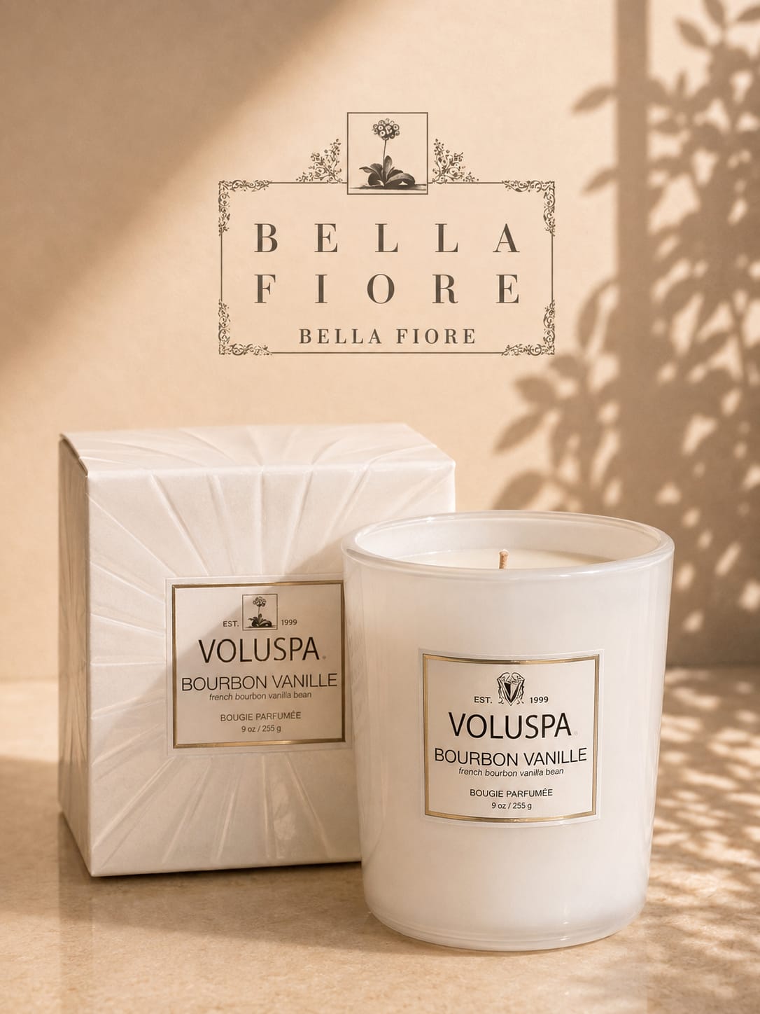 White scented candle with matching box on a beige surface