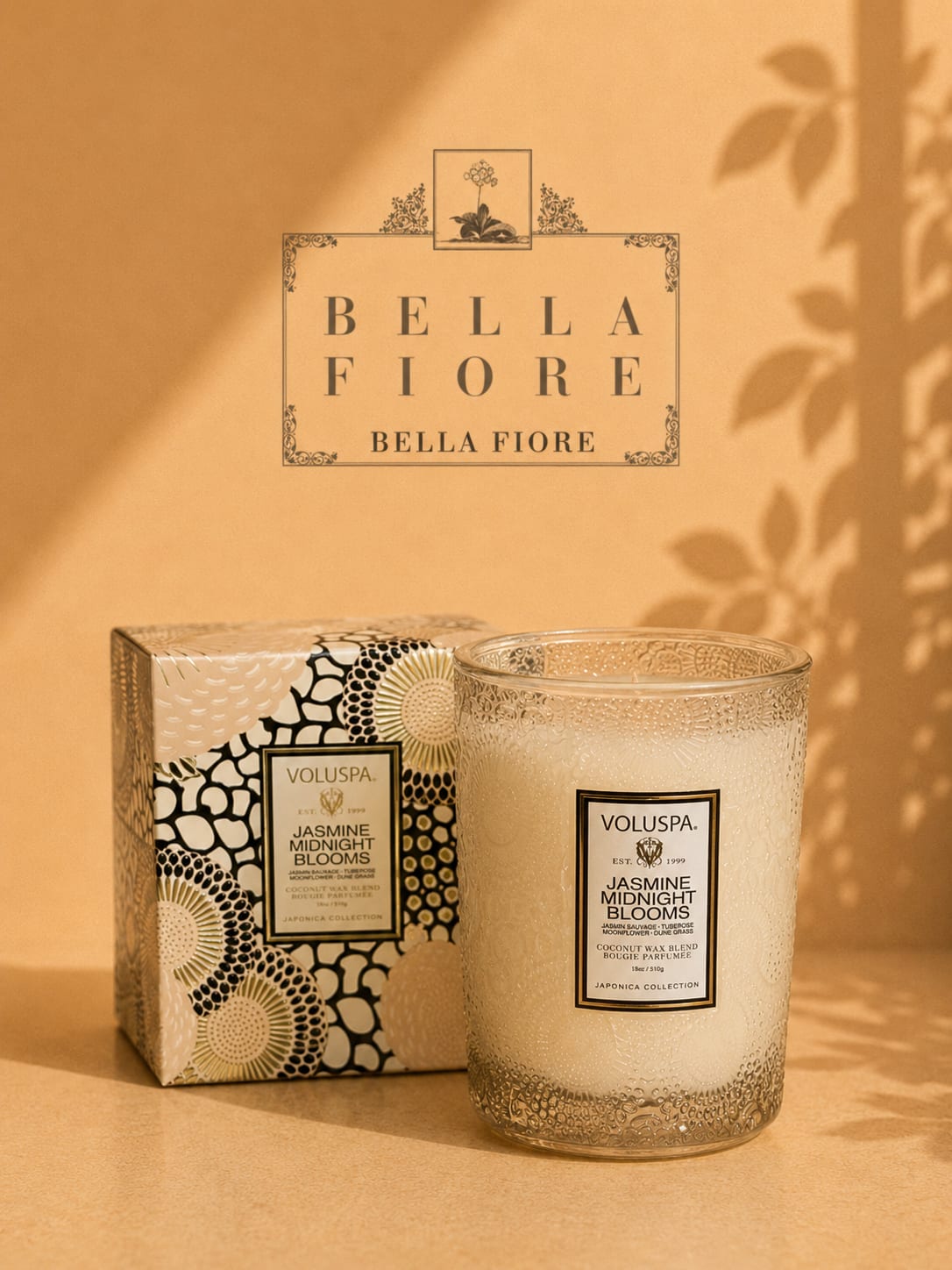 Glass candle in a patterned box beside a matching candle jar