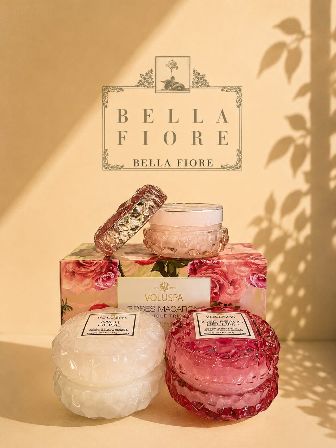Stacked scented candles in pink and white glass jars with floral packaging