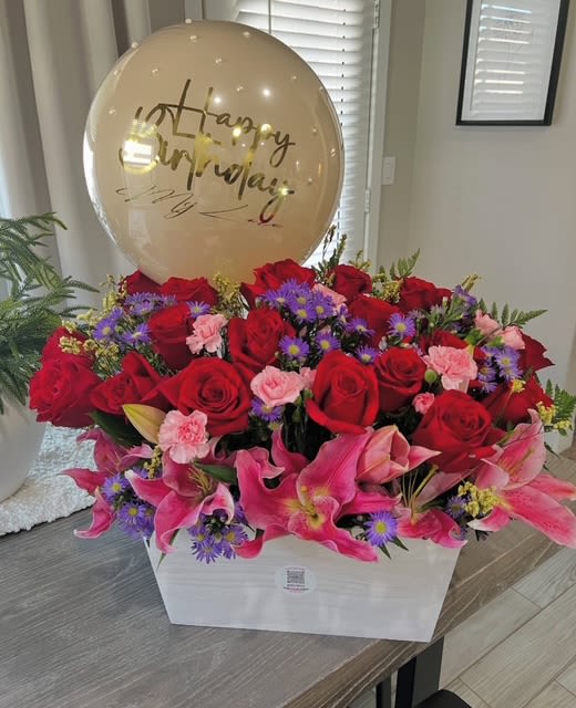 Red roses and pink lilies in a white box with a birthday balloon