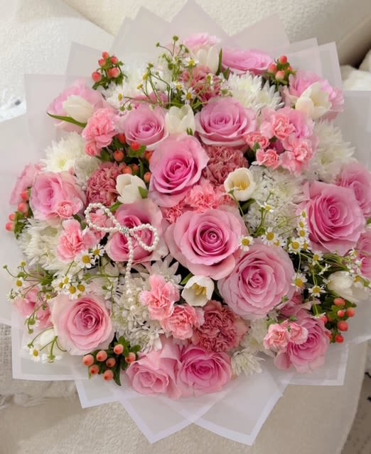 Pink rose bouquet with white accent flowers and paper wrap
