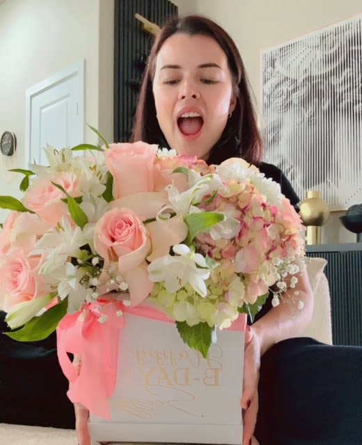 Woman holding a pastel pink flower box with roses and hydrangeas