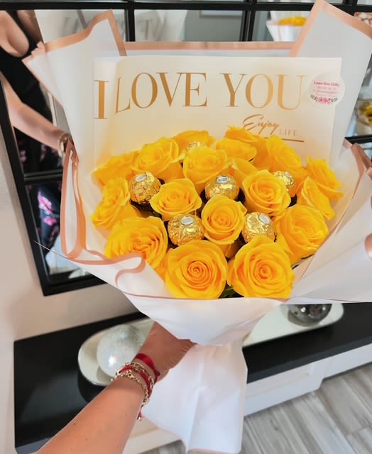 Yellow rose bouquet with gold-wrapped chocolates in white and peach wrapping