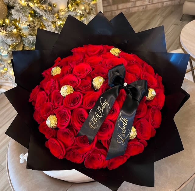 Red rose bouquet with gold-wrapped chocolates and black ribbon