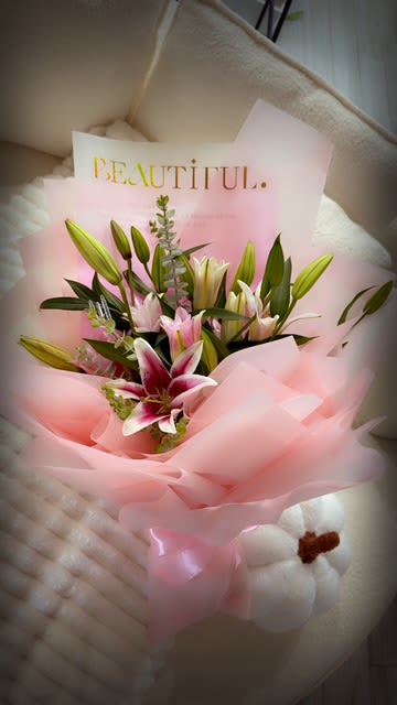 Bouquet of pink and white lilies wrapped in pink paper
