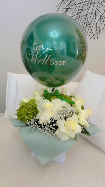 White roses and green hydrangea with a teal get well soon balloon