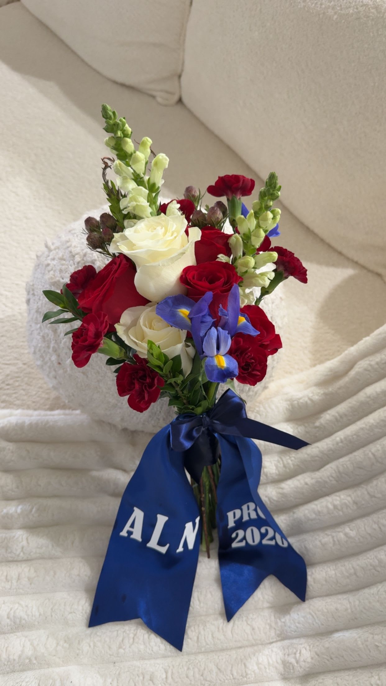 Royal Classic Prom Bouquet - A bold and elegant mix of red and white blooms with touches of blue for contrast. Hand-tied and finished with a custom personalized ribbon.
