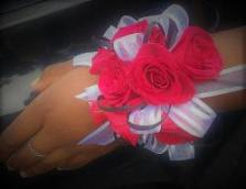 Hand corsage with bright pink roses and white ribbon