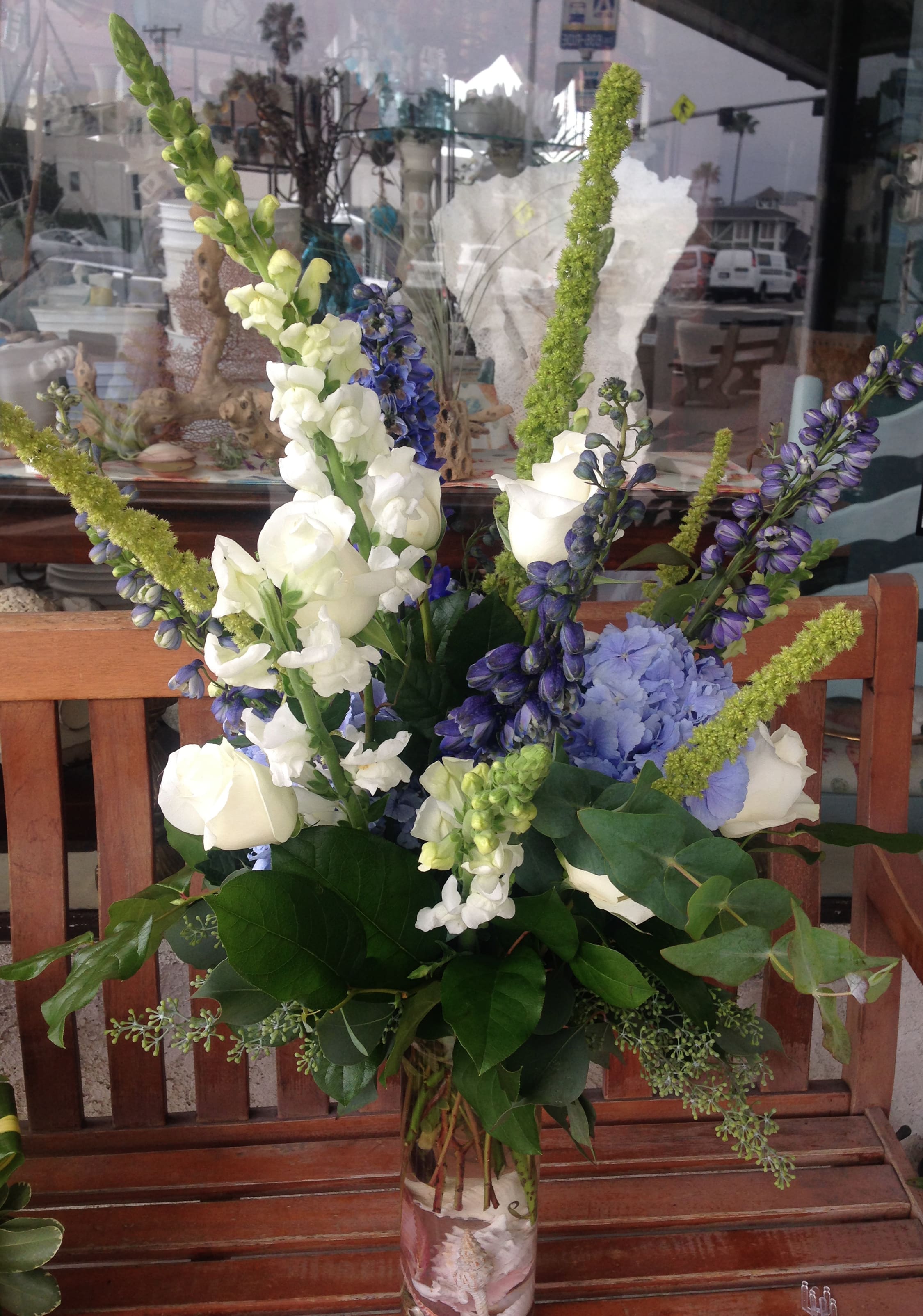 Tall bouquet of white and purple flowers in a glass vase