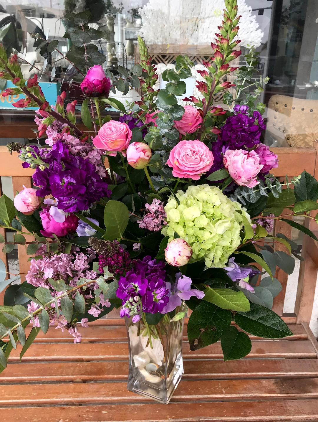 Mixed pink and purple floral arrangement in a clear glass vase