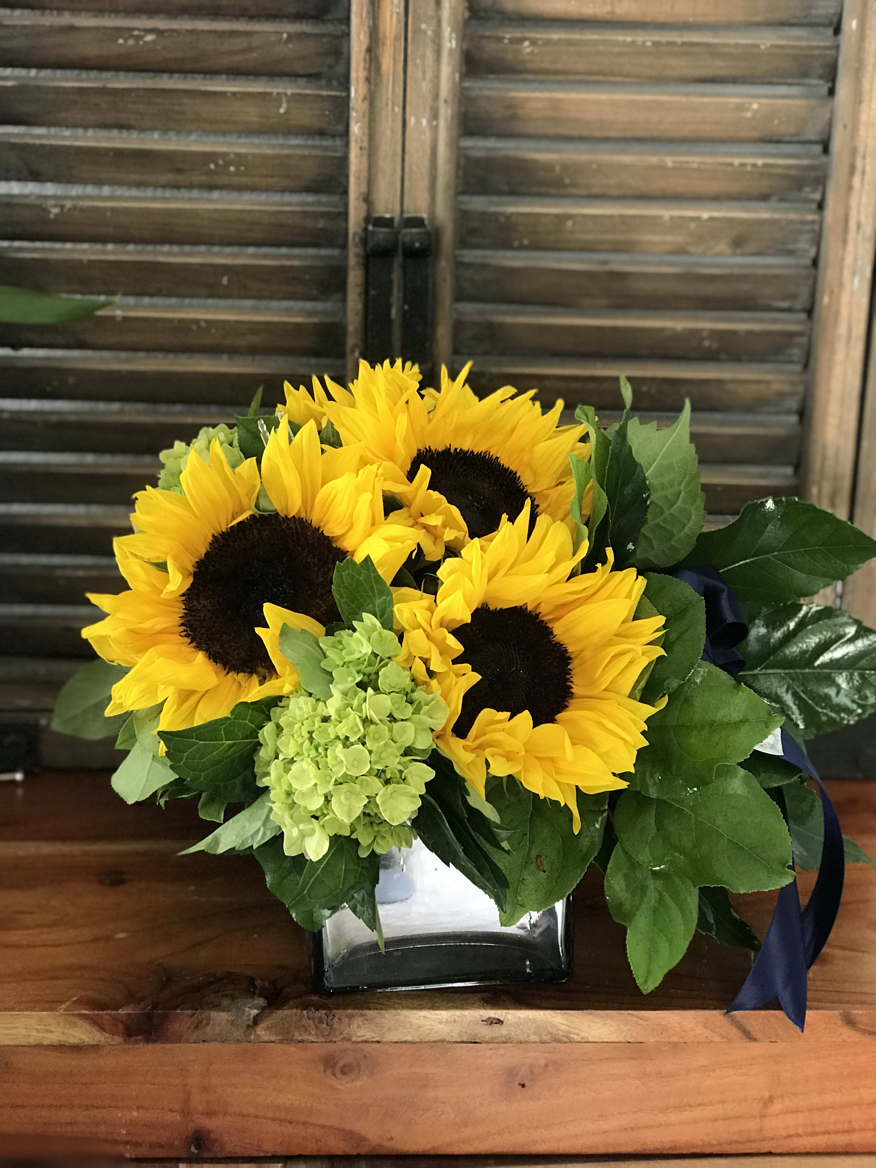 Sunflower bouquet with green hydrangea in a glass vase