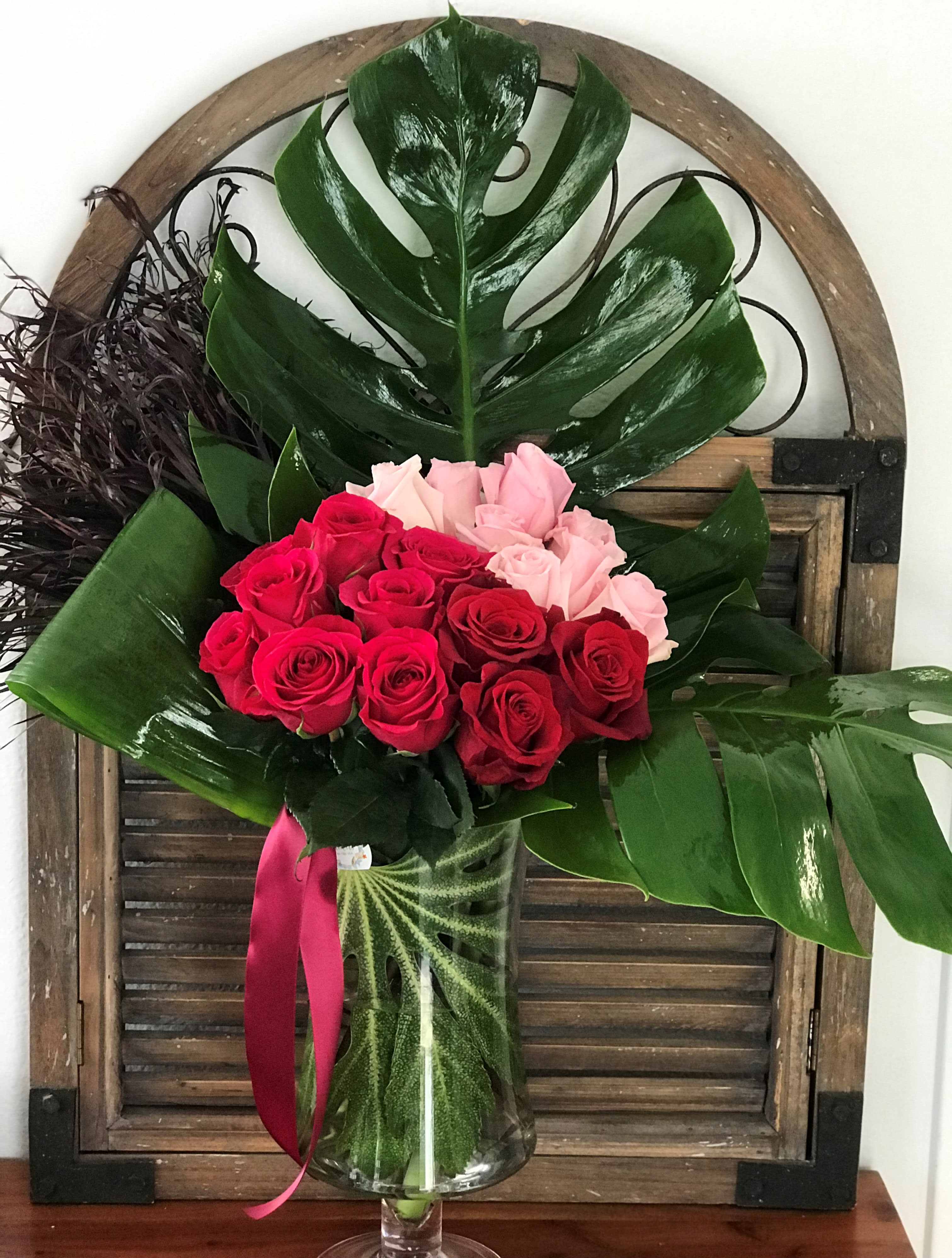 Bouquet of red and pink roses in a clear glass vase