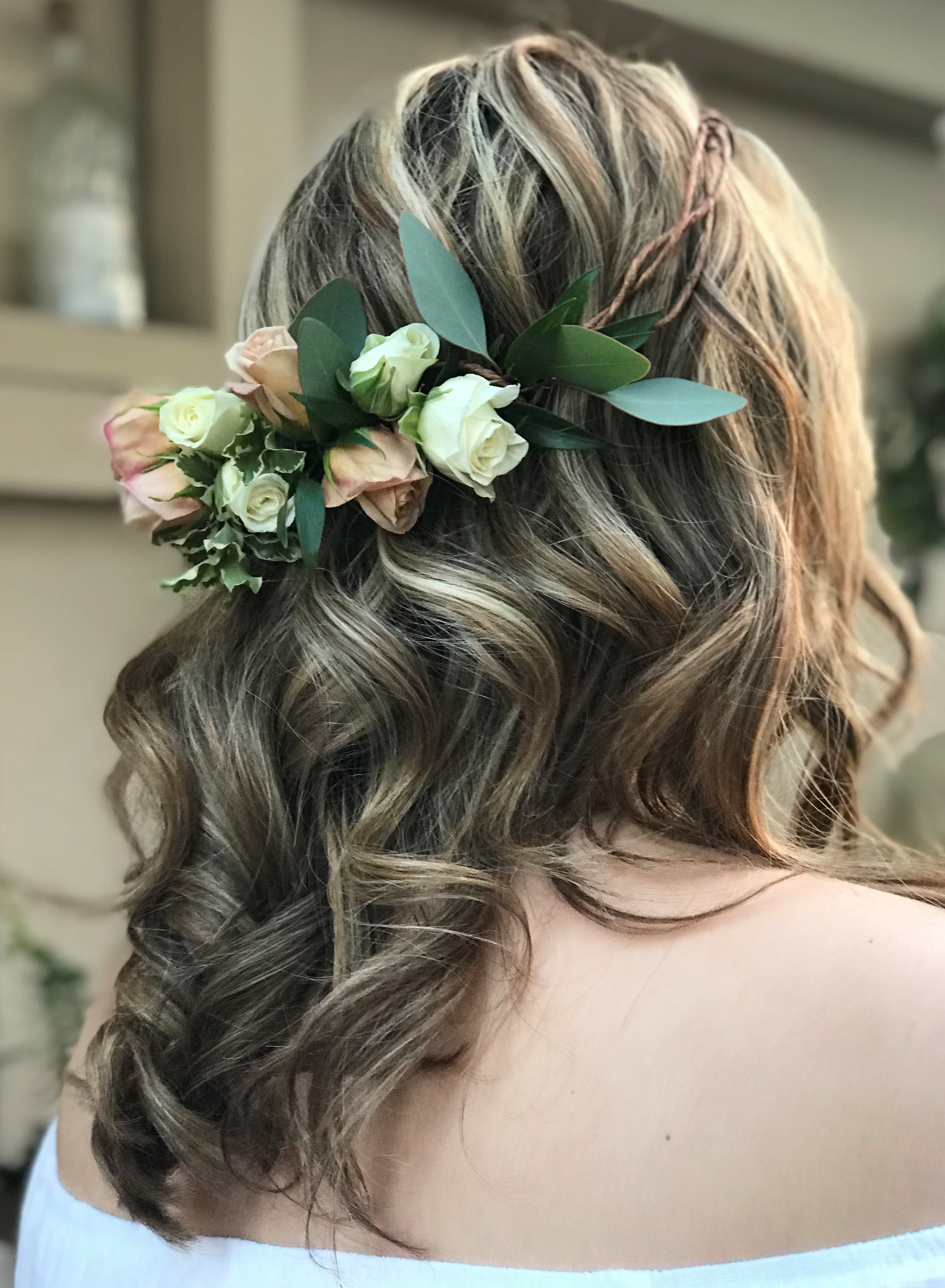 Floral hairpiece with blush and white roses in a woman's hair