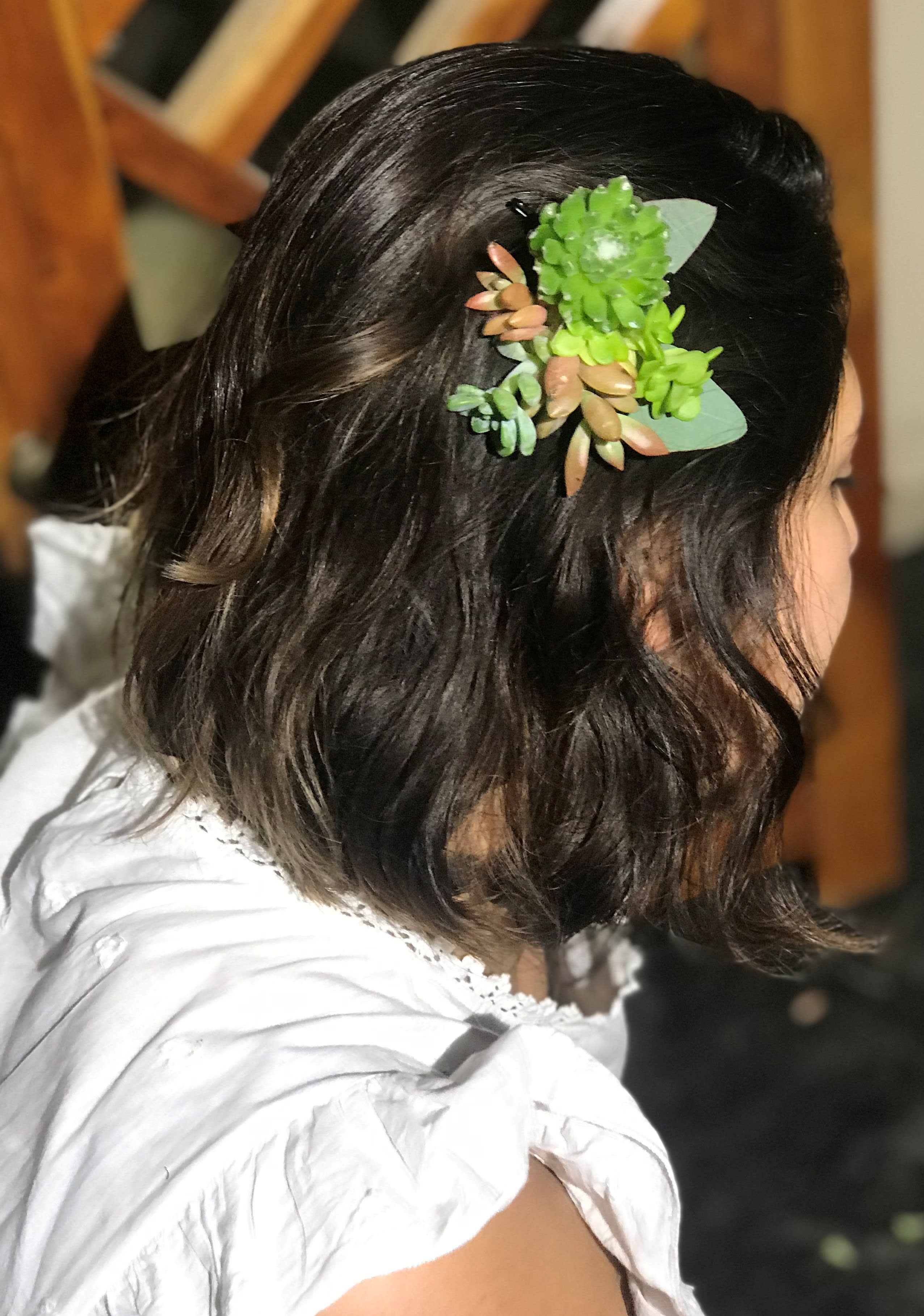 Woman with a green succulent hair clip in dark hair