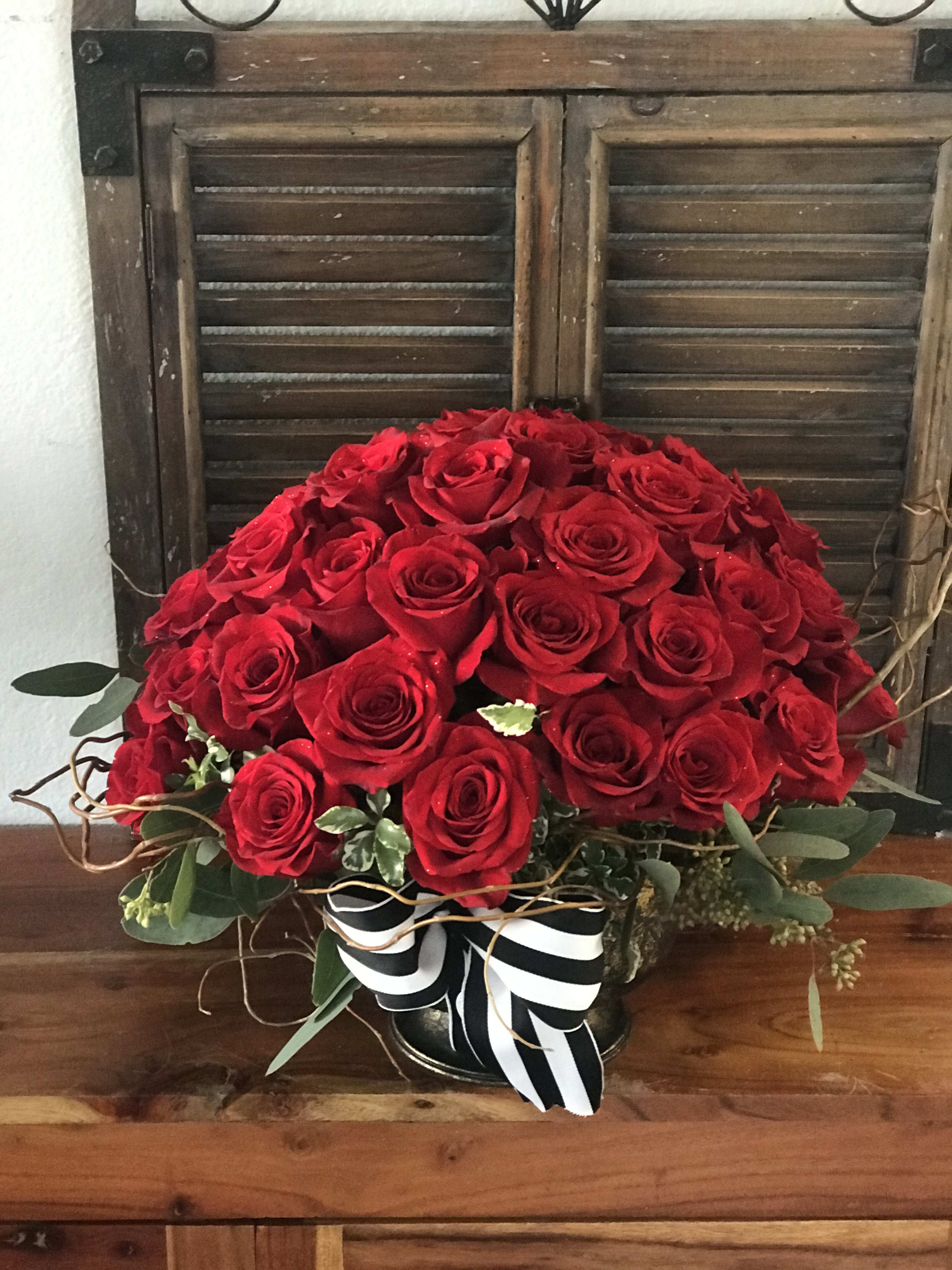 Large bouquet of red roses with a black-and-white ribbon