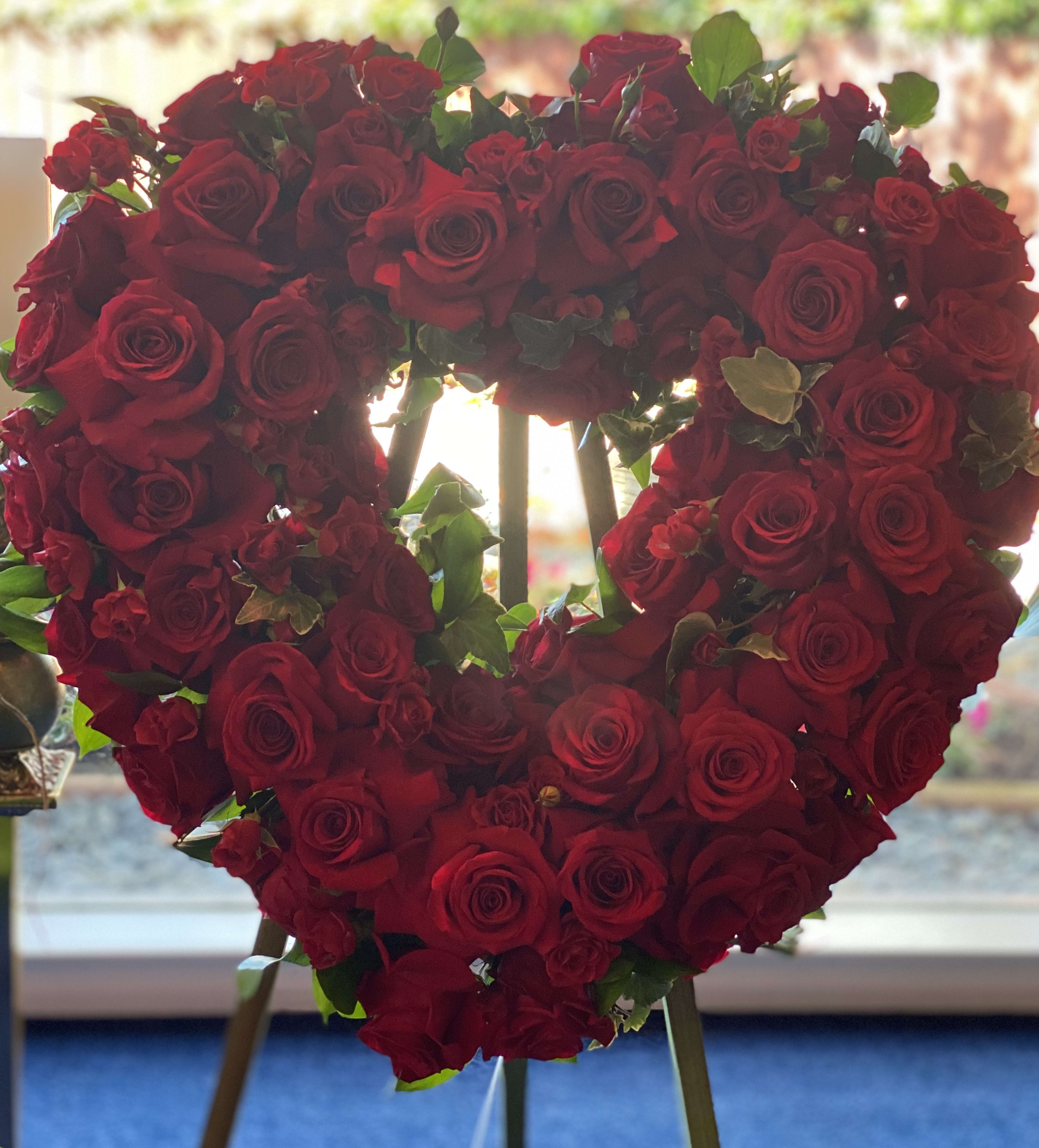 Heart-shaped arrangement of red roses on an easel