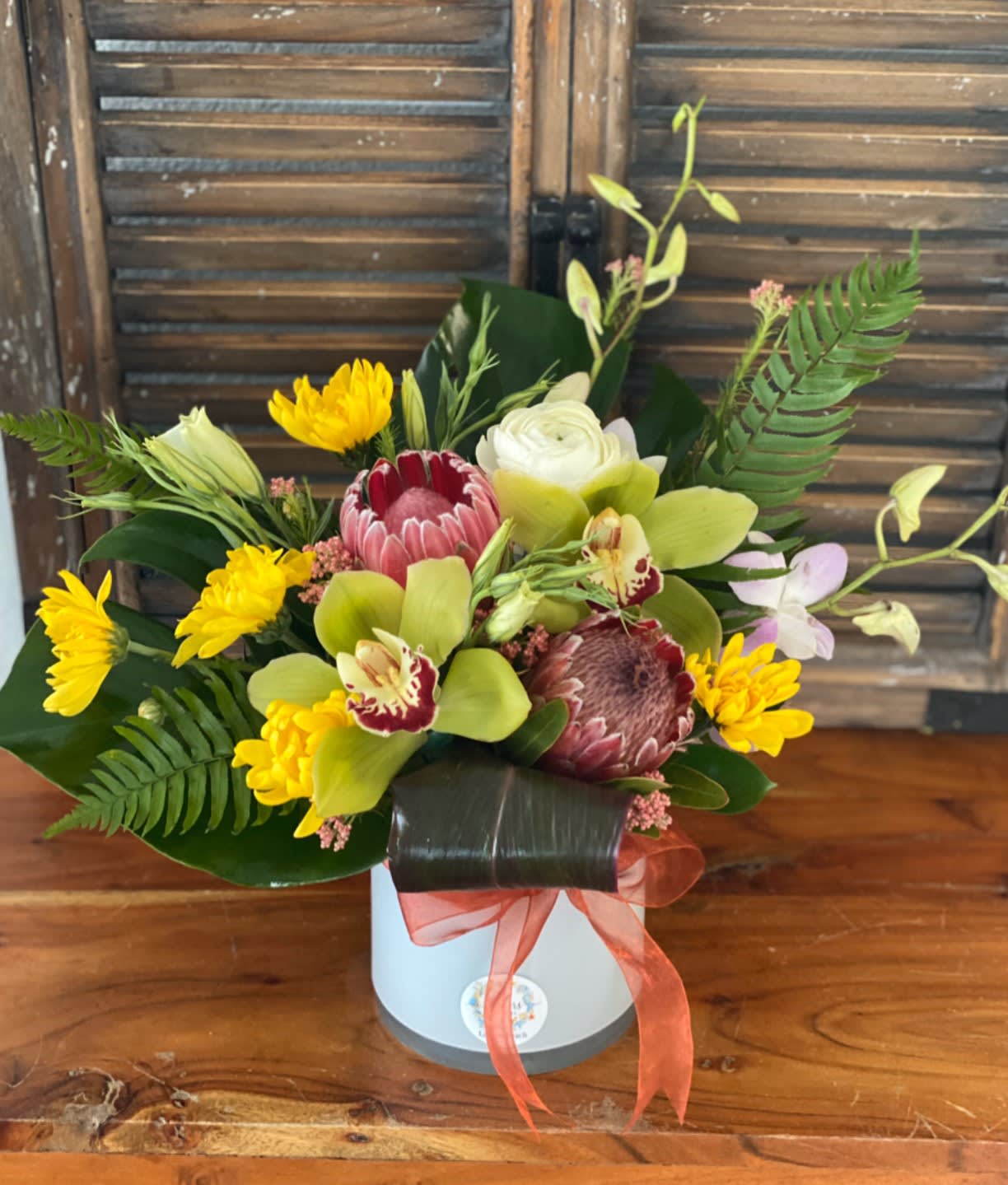 Mixed tropical bouquet in a white box with a coral ribbon
