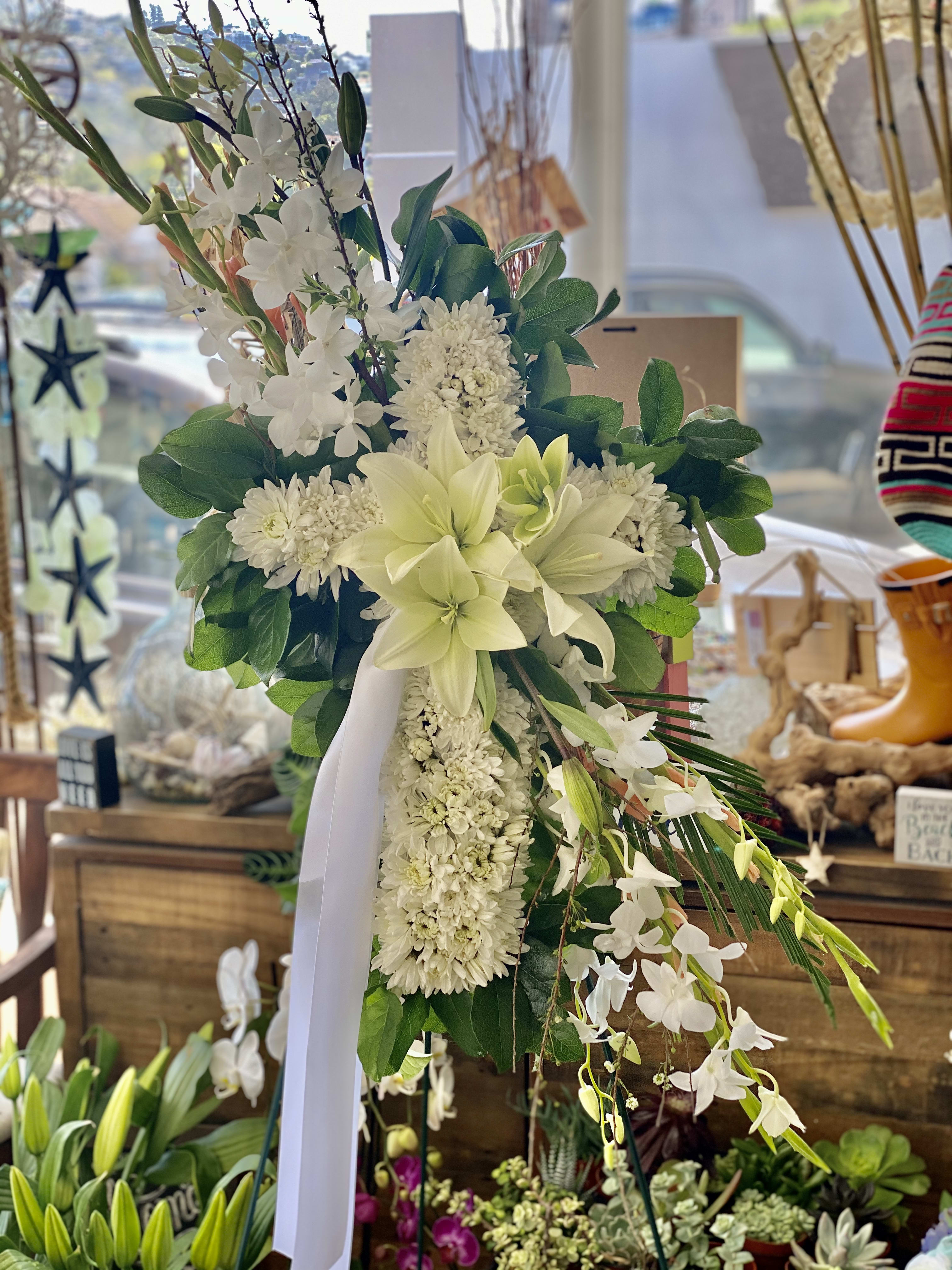 White floral standing spray with lilies and orchids on a ribboned easel