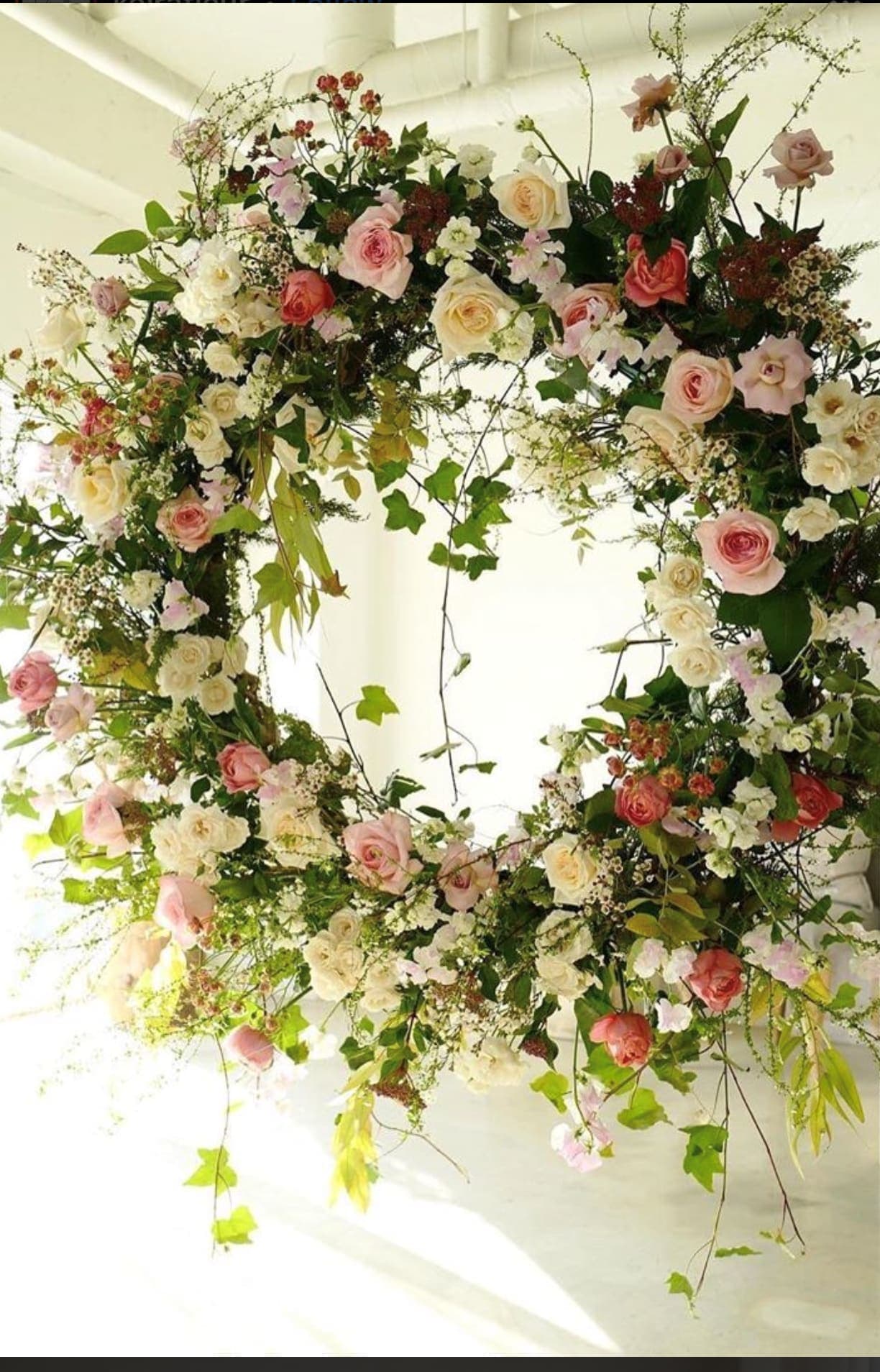 Large circular floral wreath with pink and white roses