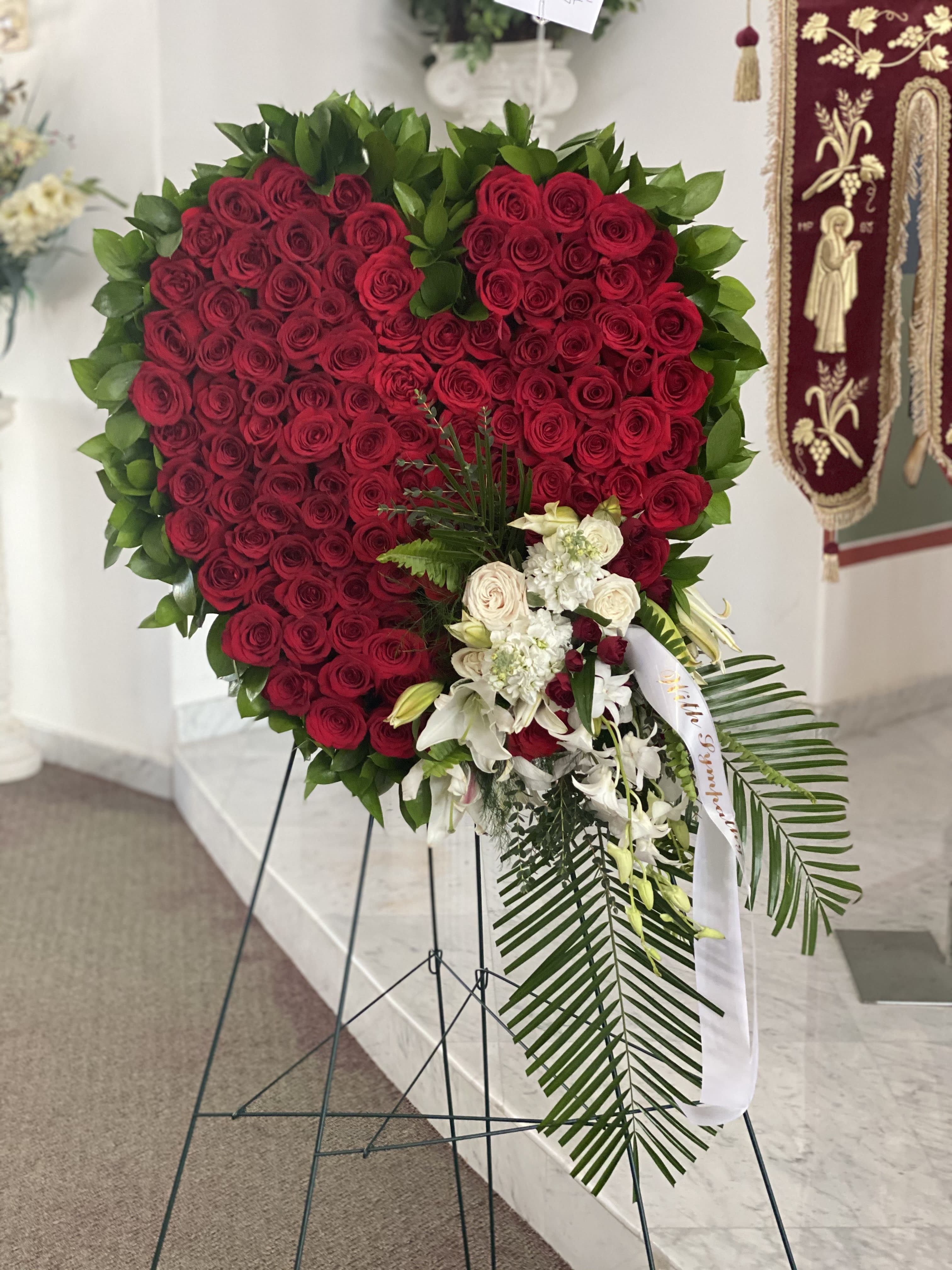 Heart-shaped red rose standing spray with white flowers and greenery