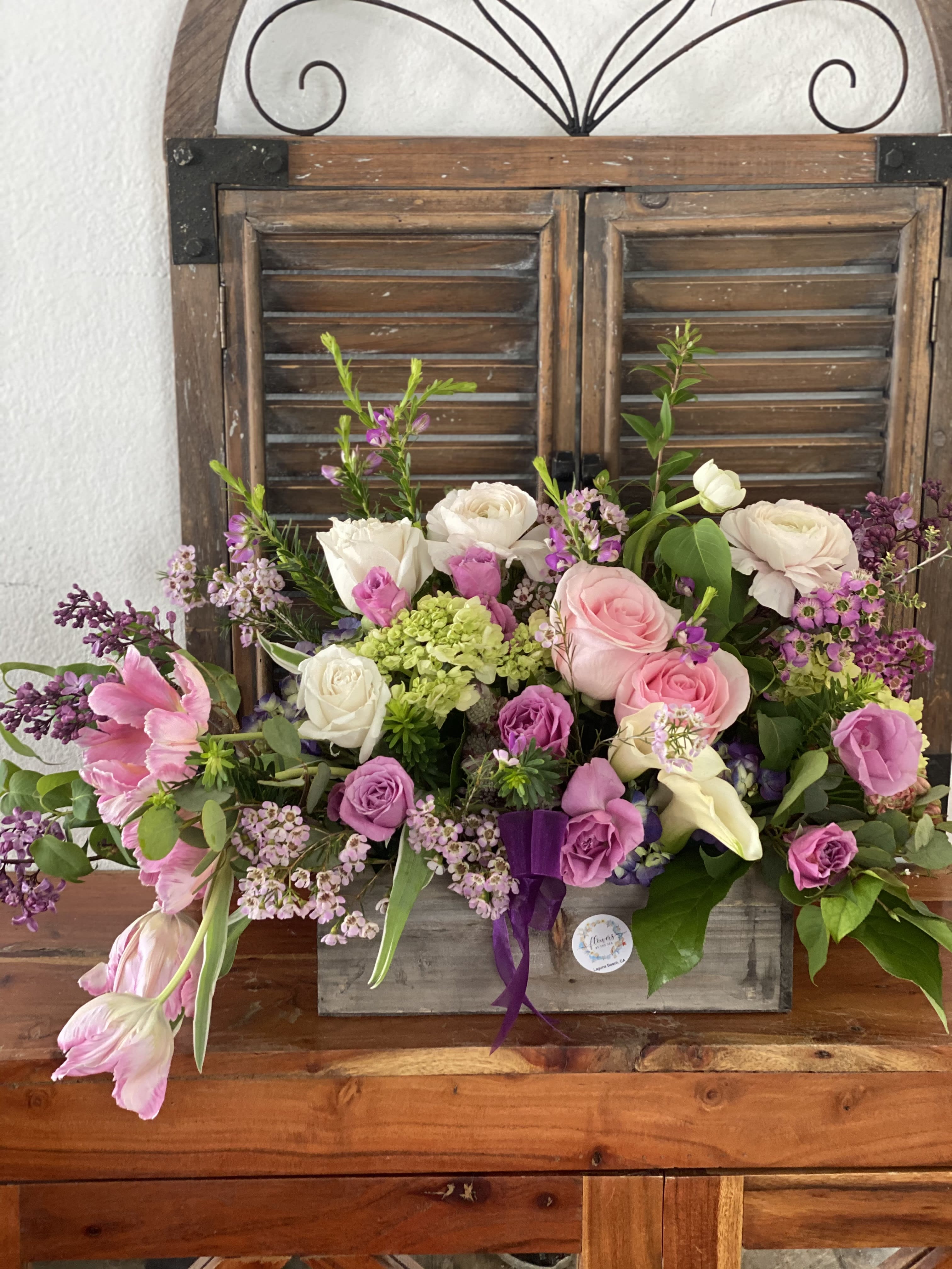 Mixed pink and white flower arrangement in a rustic wooden box