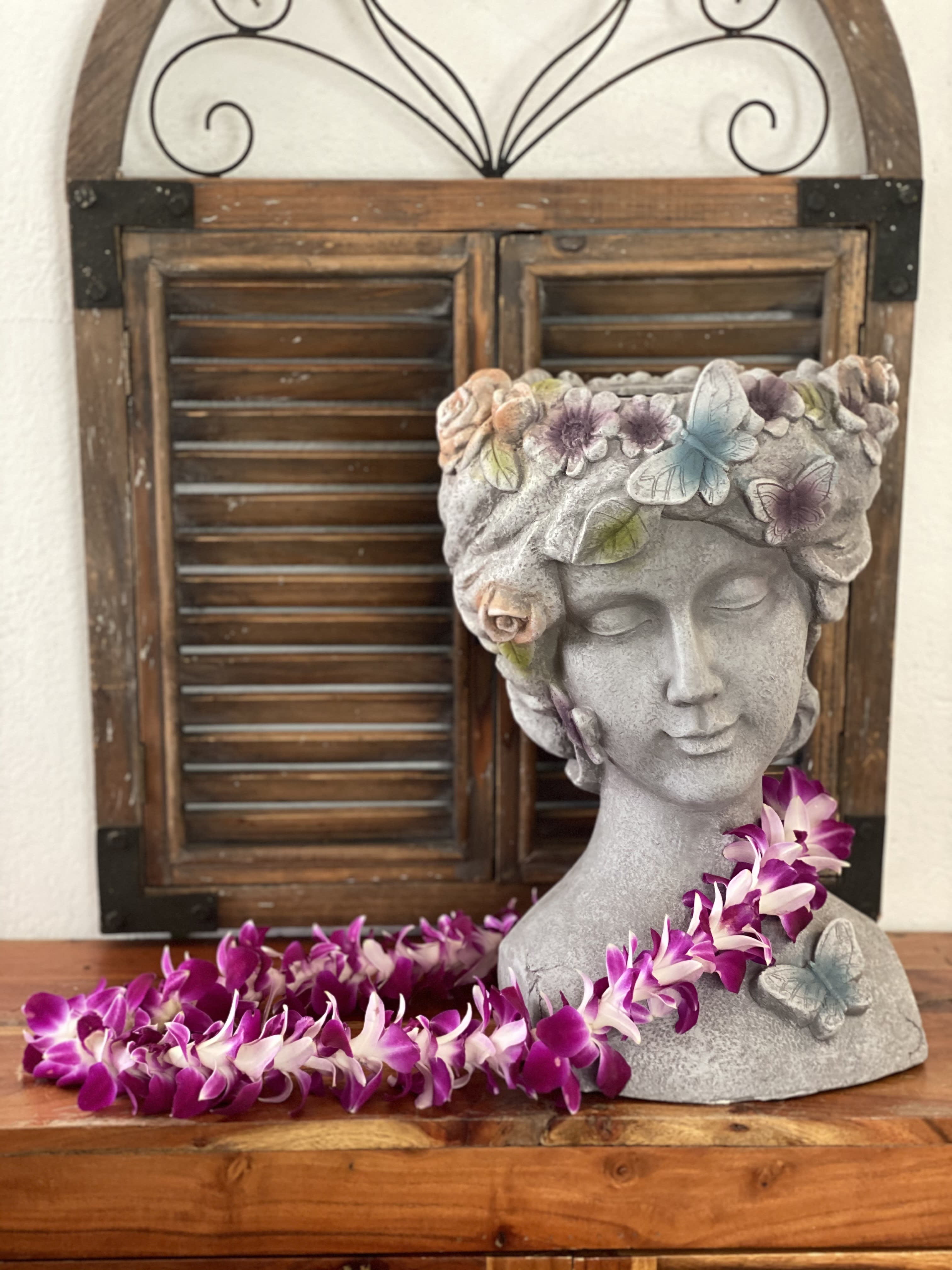 Stone bust planter with purple orchid garland and butterfly accents