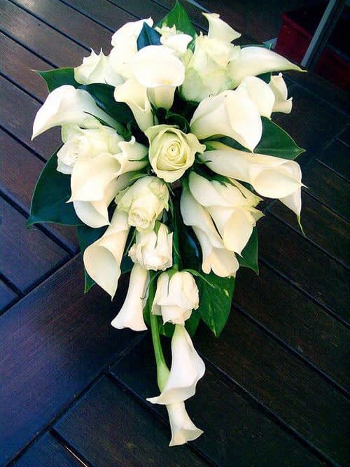 White calla lily and rose bridal bouquet with dark green leaves