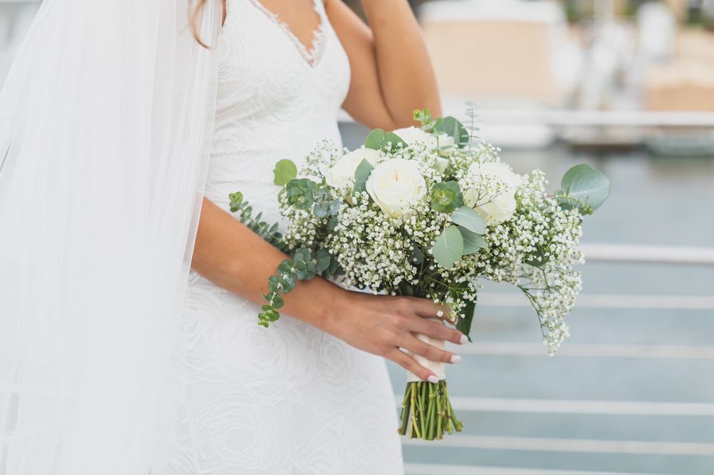 Bride holding a white rose bouquet with baby's breath and eucalyptus