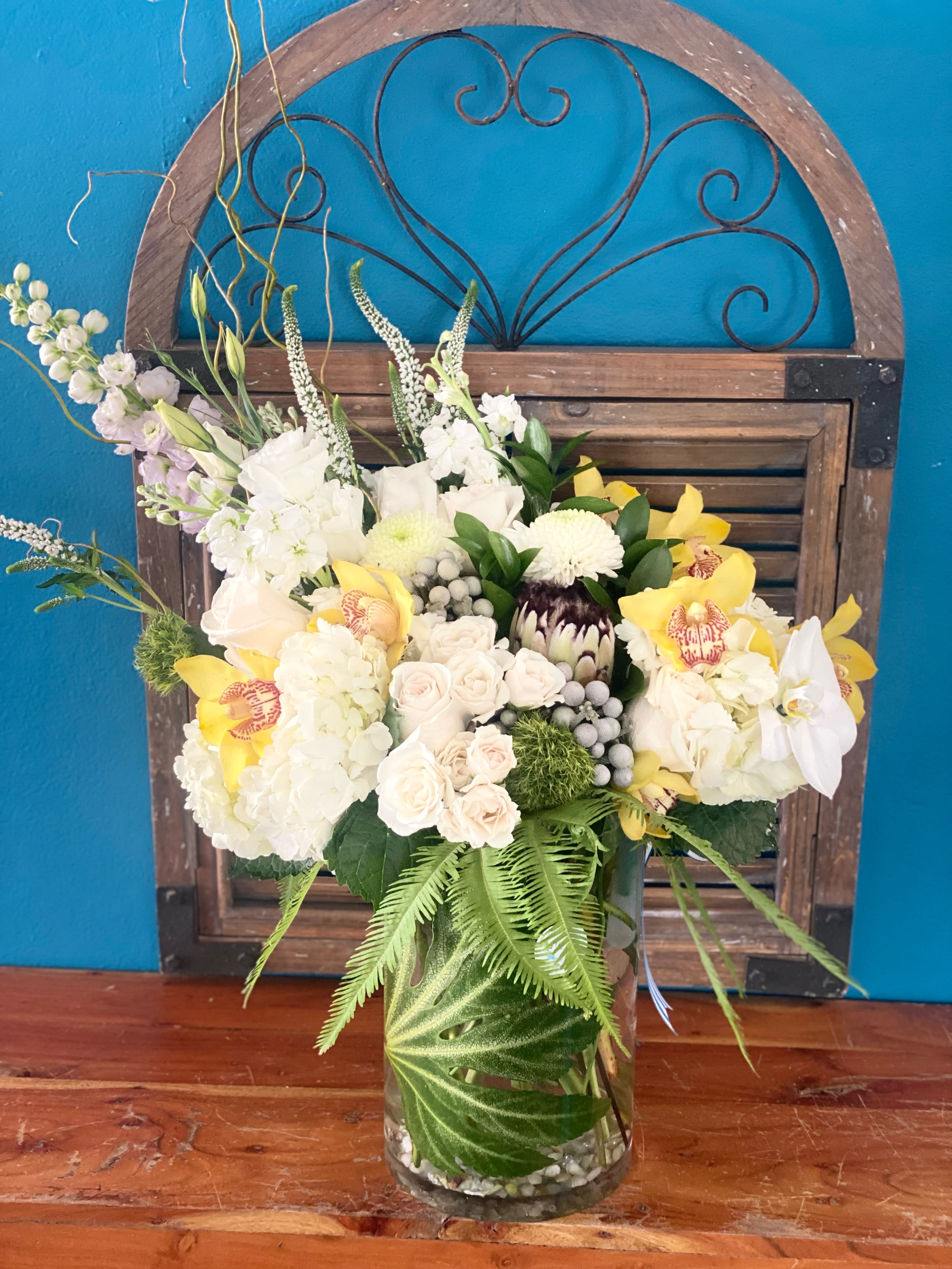 Mixed white and yellow floral arrangement in a glass vase