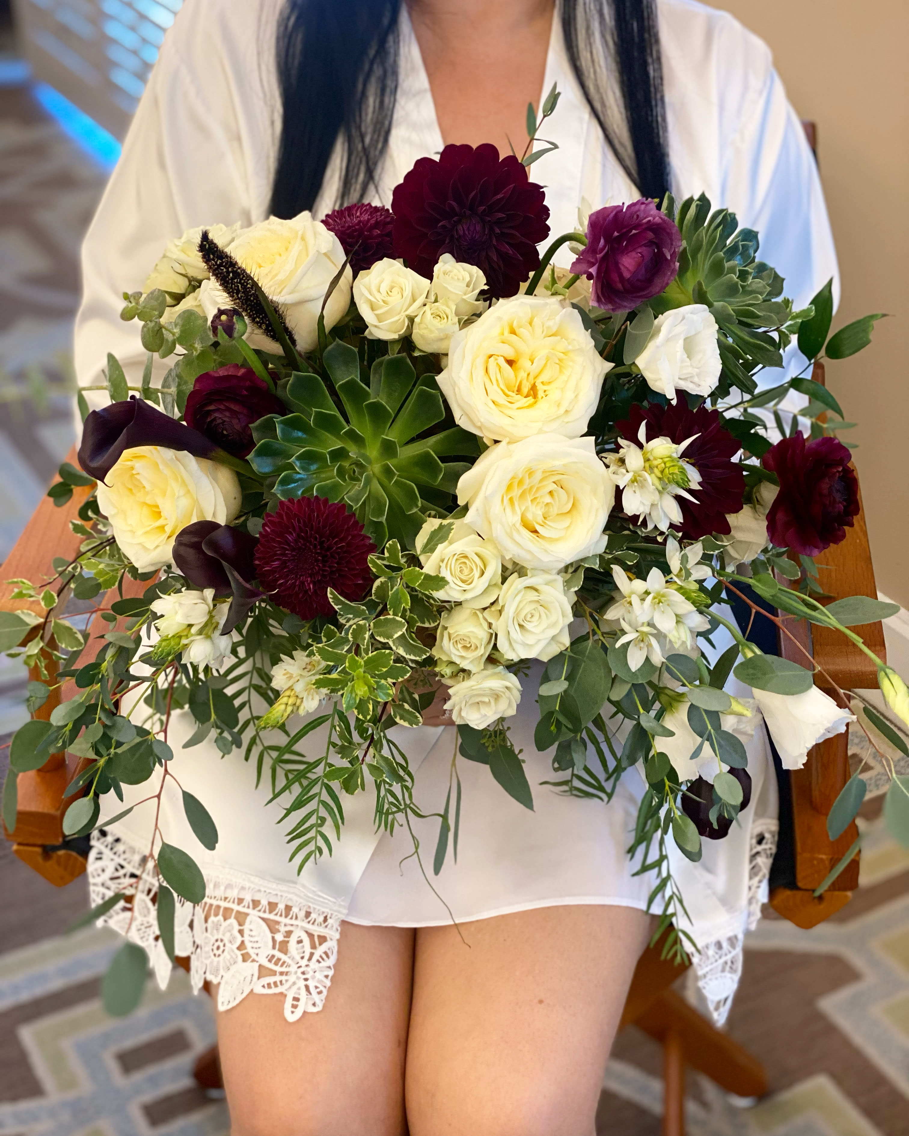 Wedding bouquet of cream and burgundy flowers with greenery
