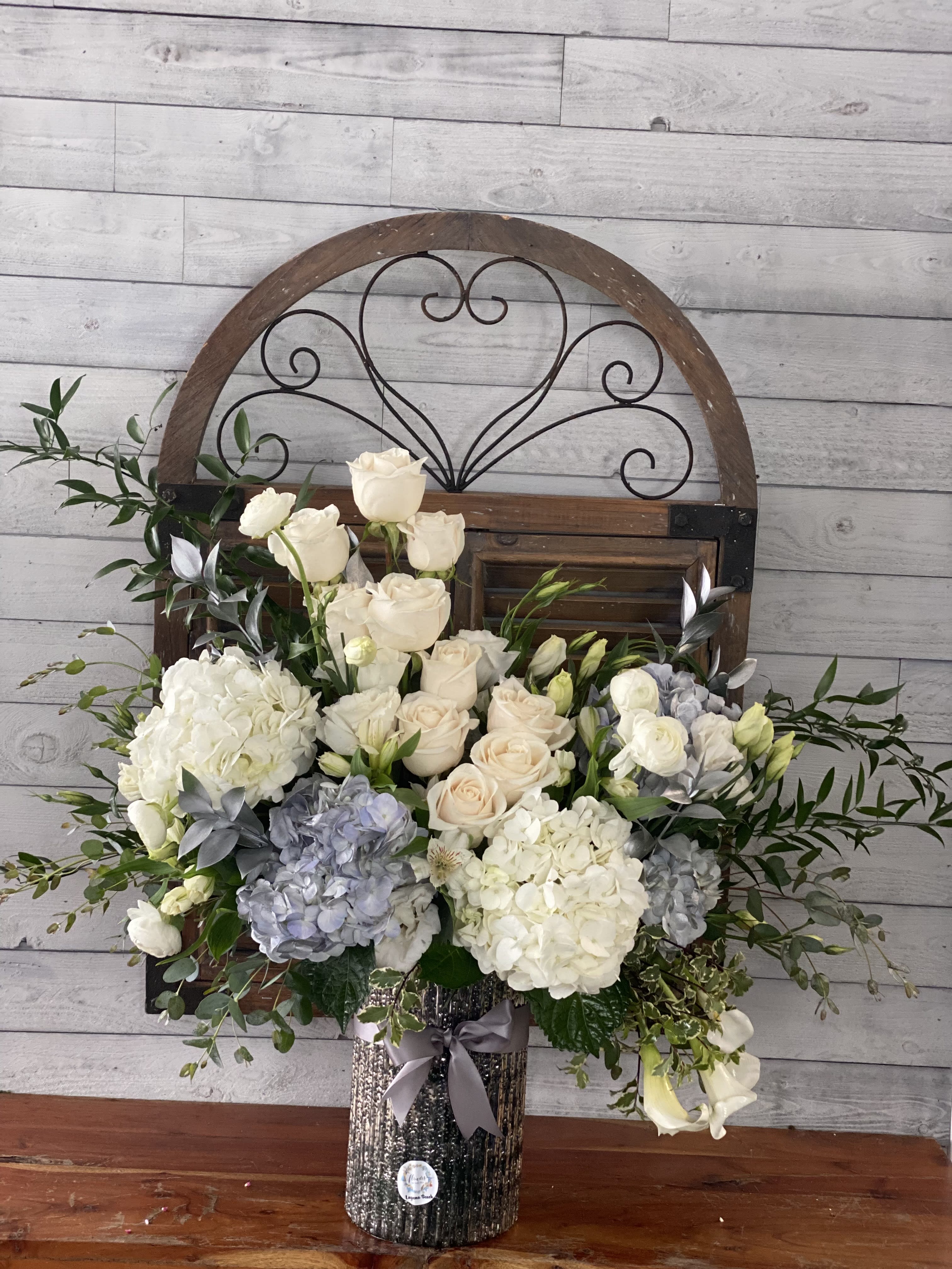 White and blush roses with hydrangeas in a glittery vase