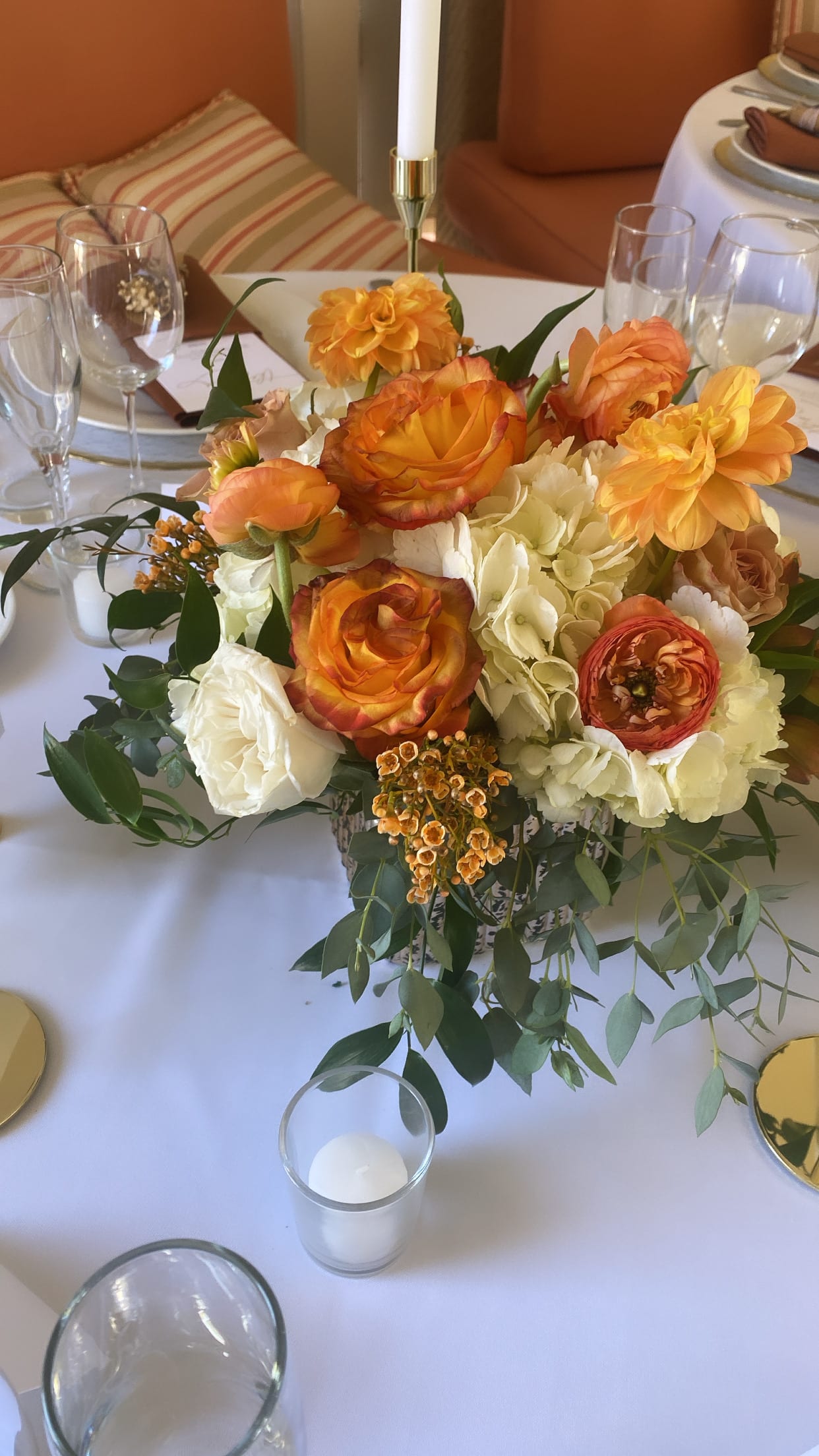 Orange and white floral centerpiece on a dining table