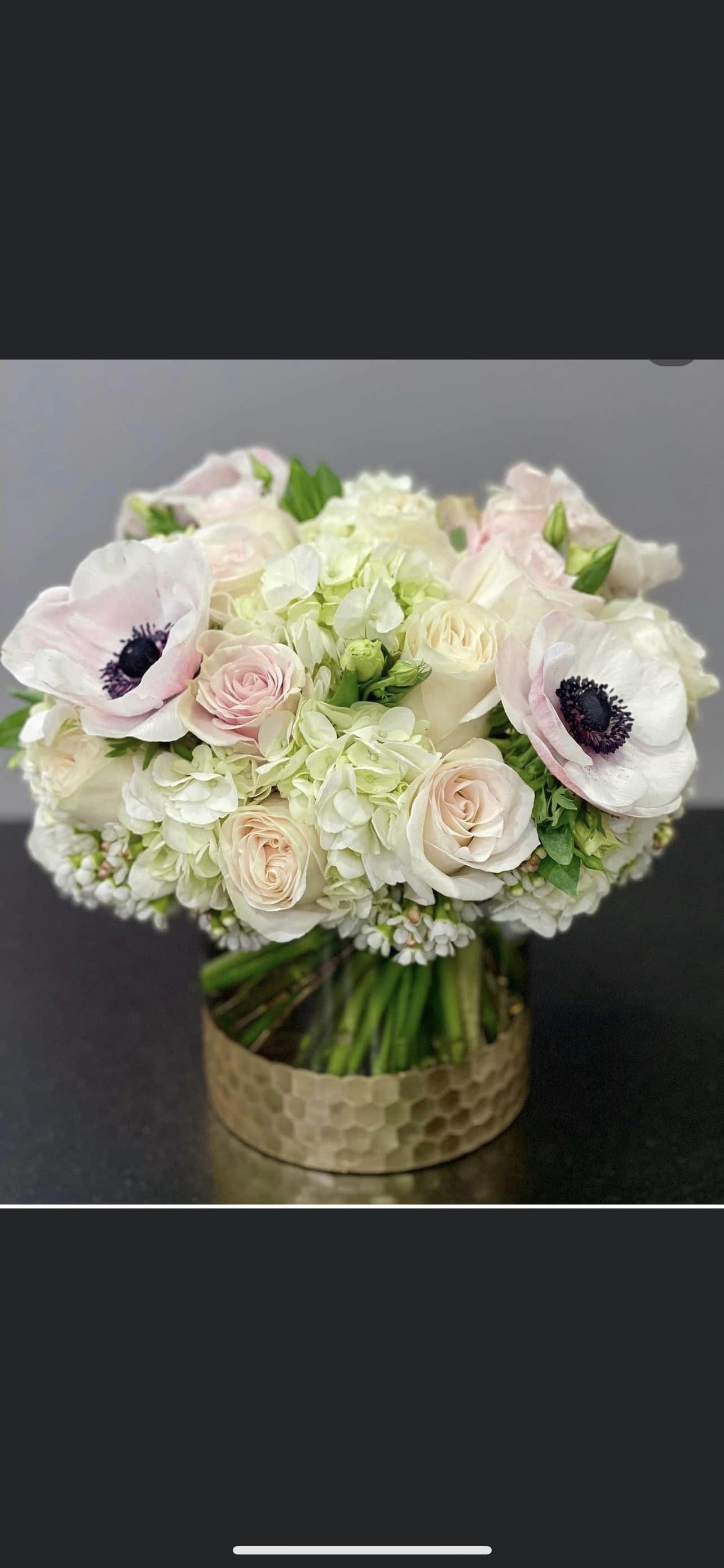 Wedding bouquet of white and blush flowers in a gold vase