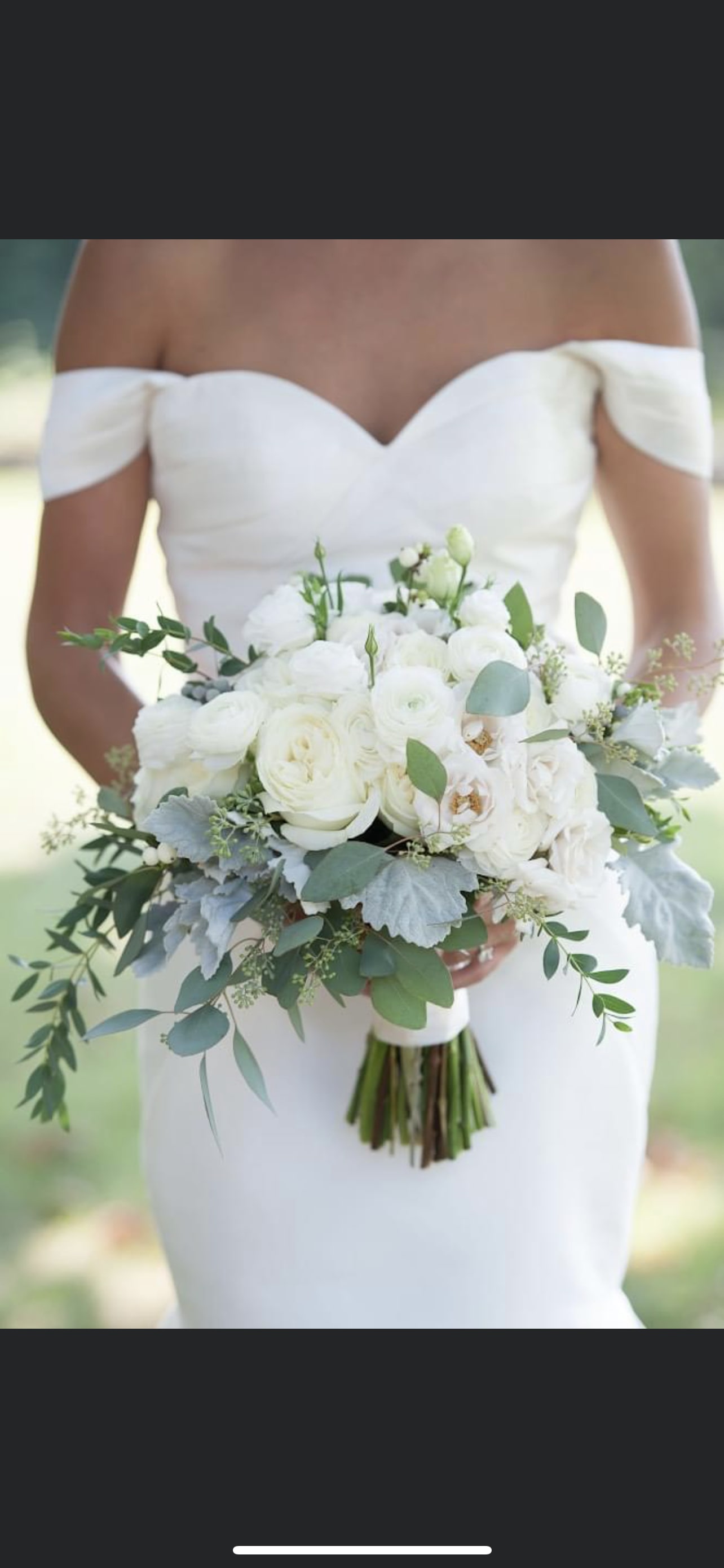 Bride holding a white bouquet with greenery