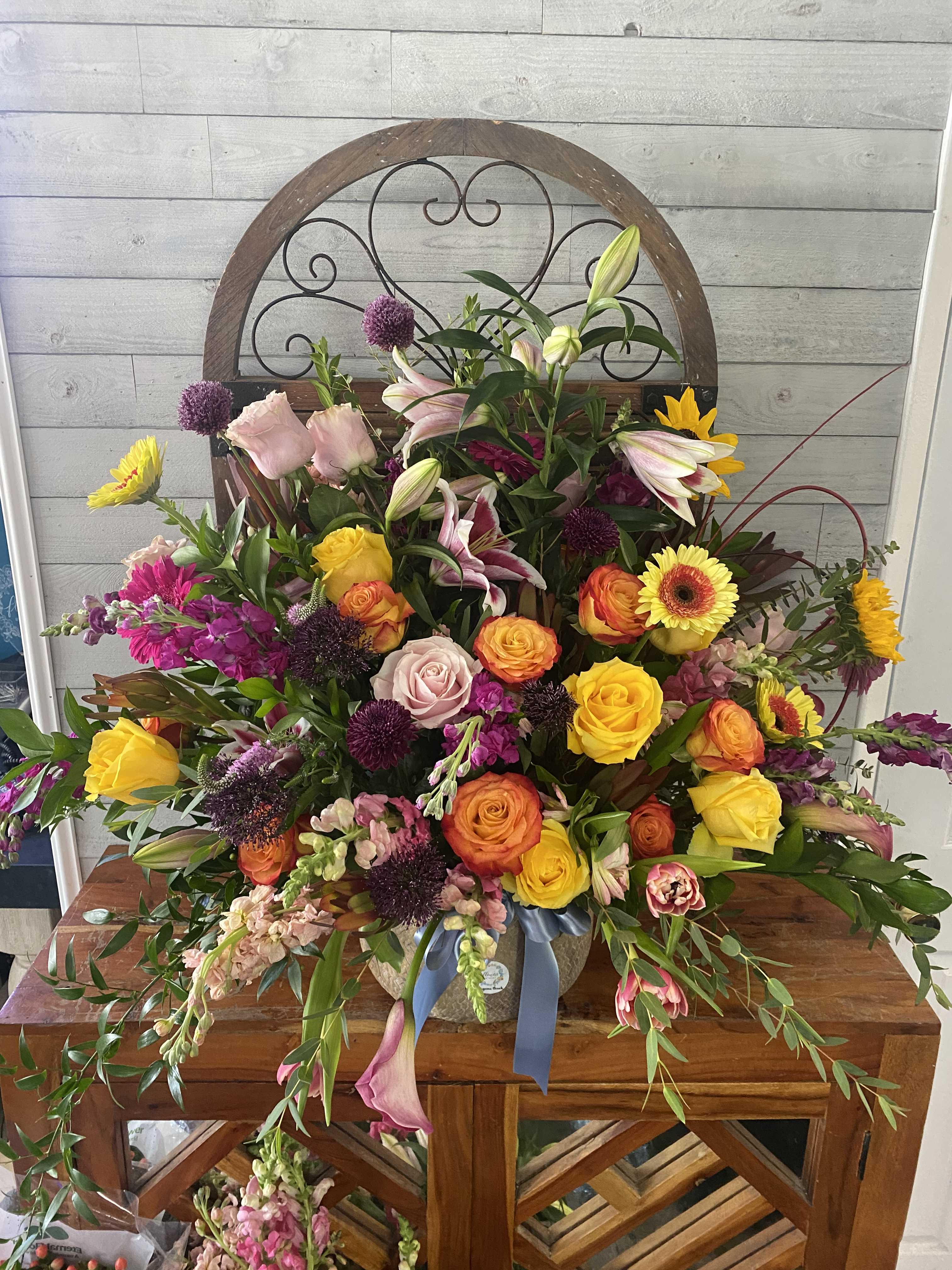 Large mixed bouquet with roses, lilies, and gerbera daisies in a vase