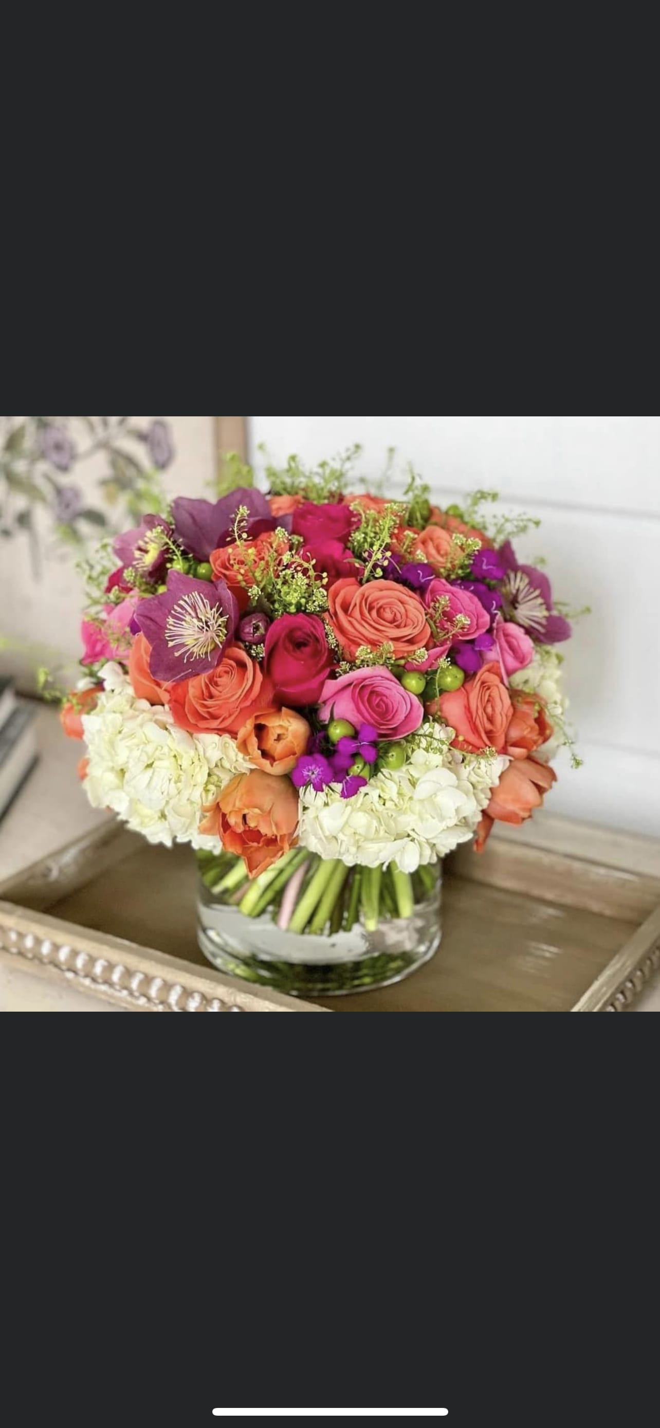 Mixed pink, coral, and purple bouquet in a clear glass vase