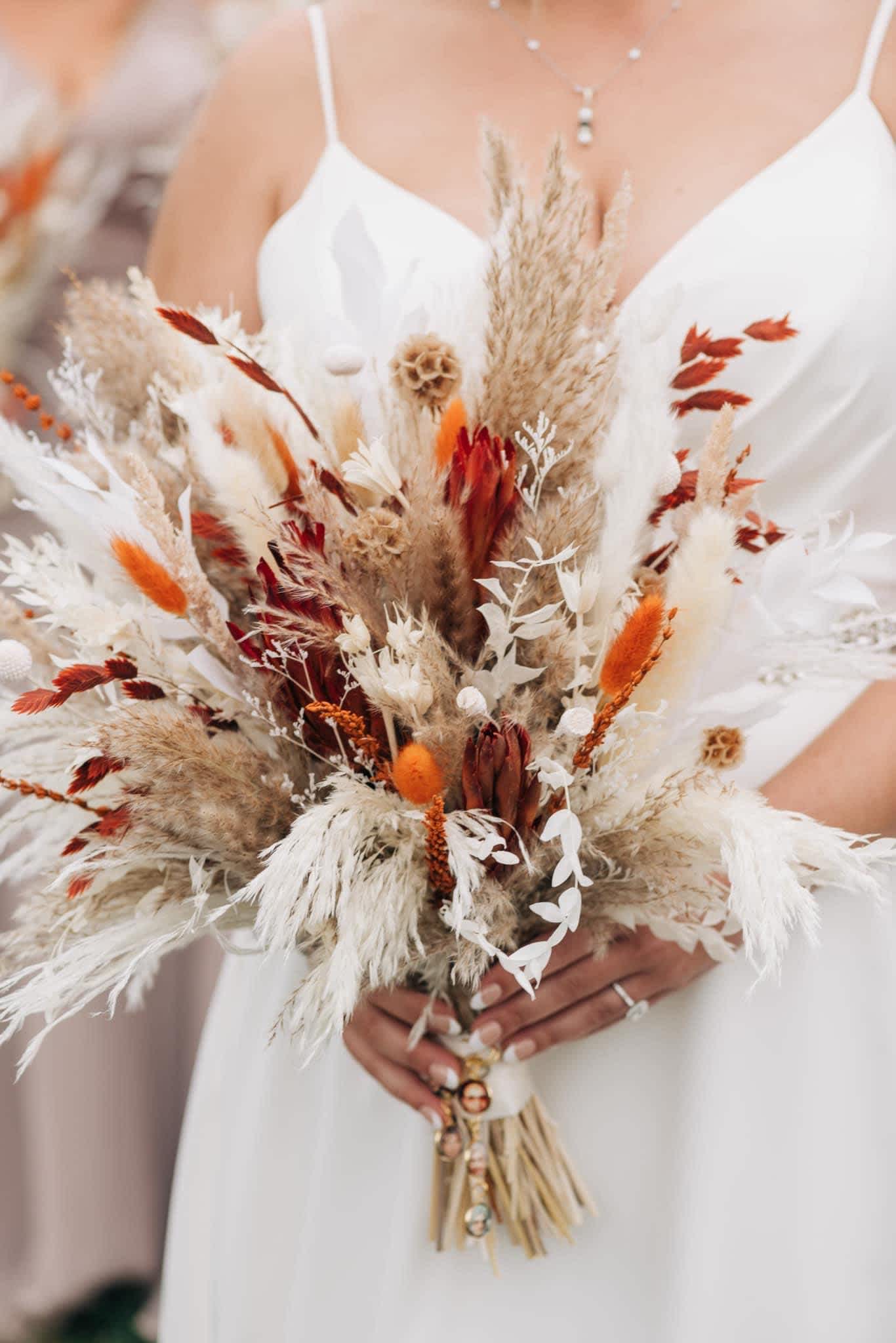 Bride holding a dried bouquet with white and rust accents