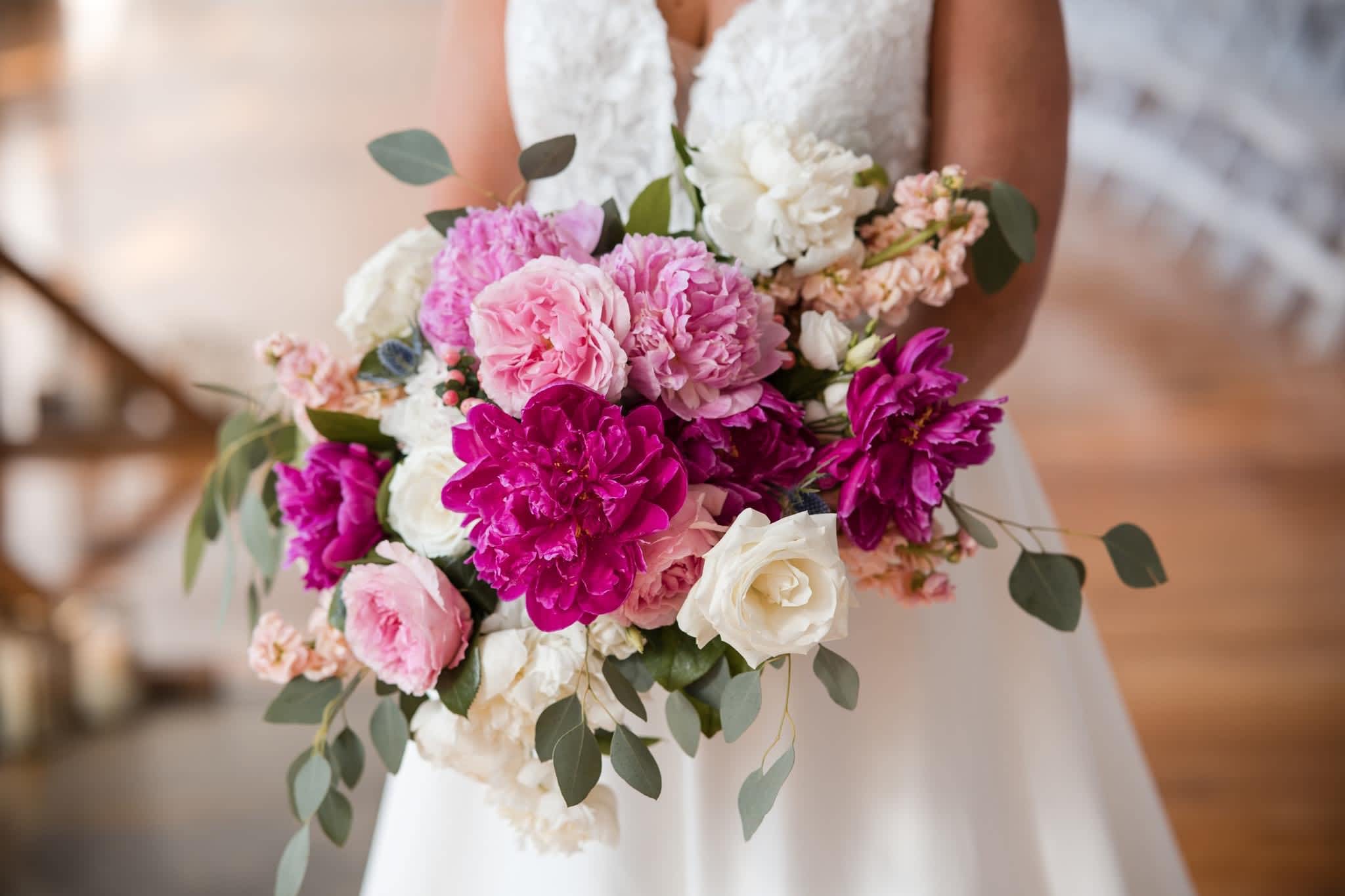 Bride holding a bouquet of pink, magenta, and white flowers