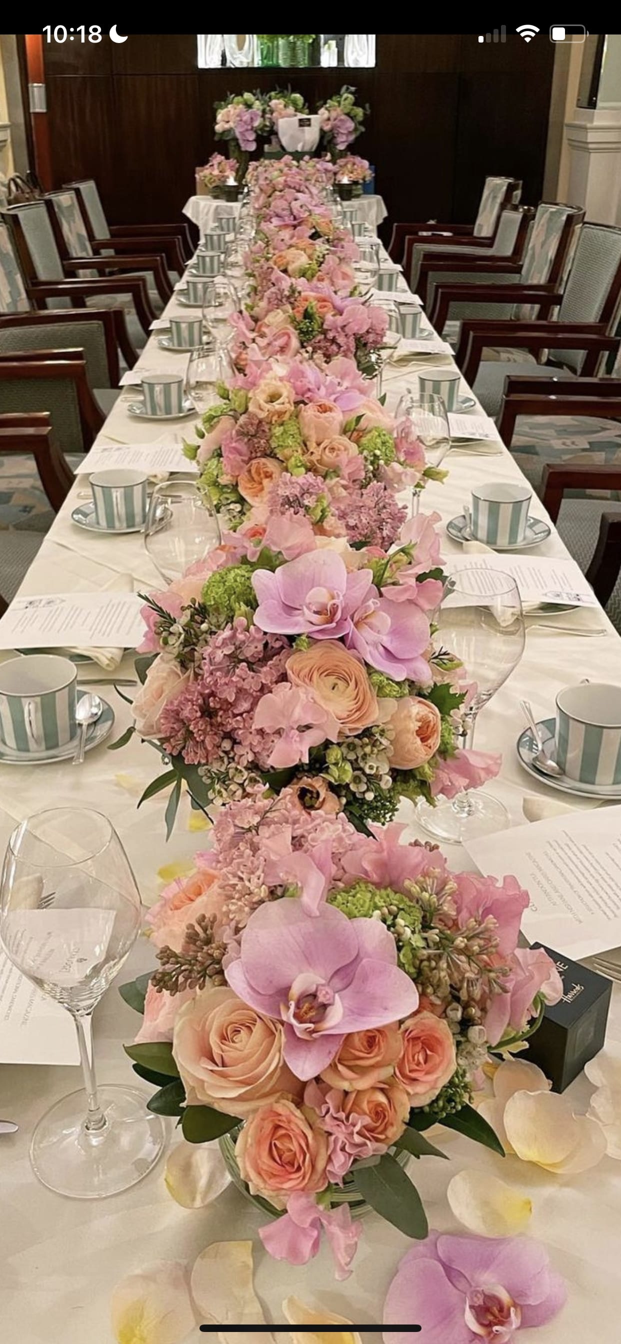 Pink and peach floral centerpieces line a long wedding table