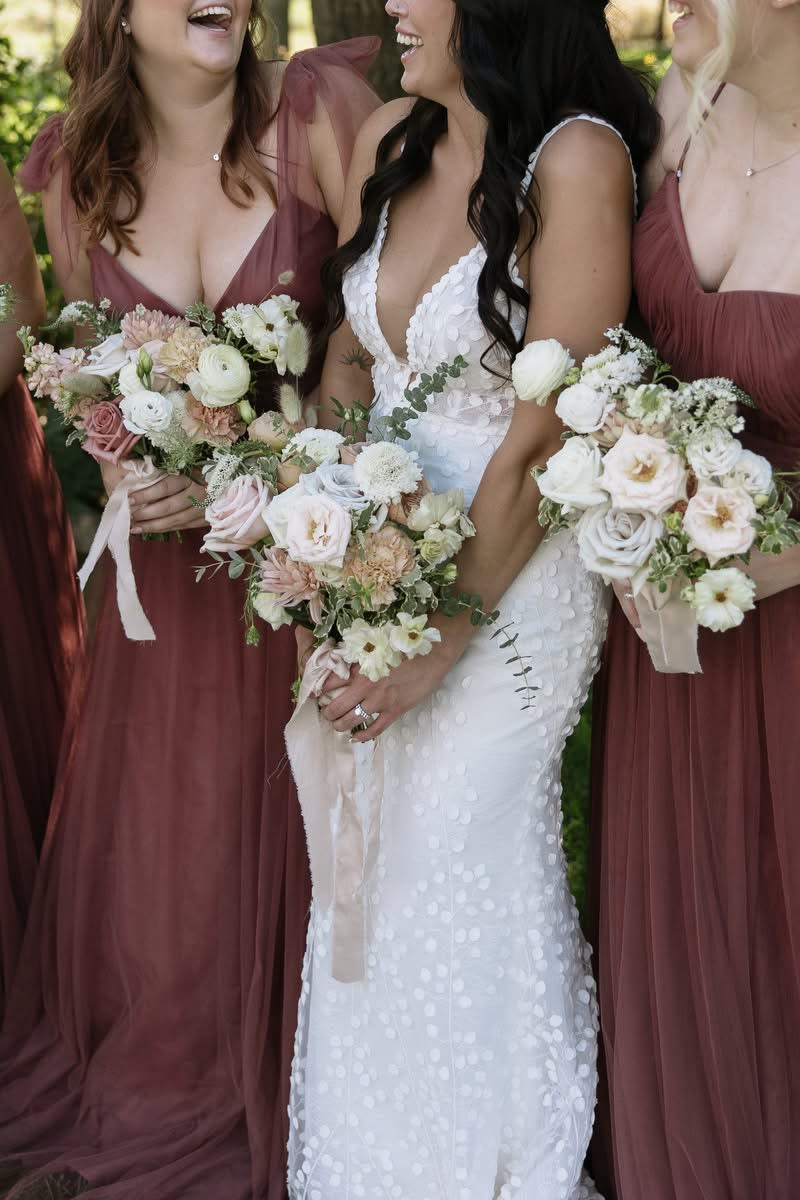 Bride and bridesmaids holding pastel wedding bouquets