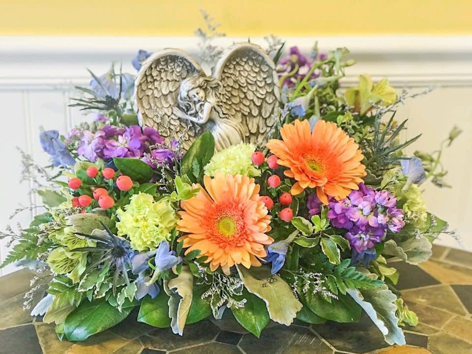 Colorful floral arrangement with an angel figurine centerpiece