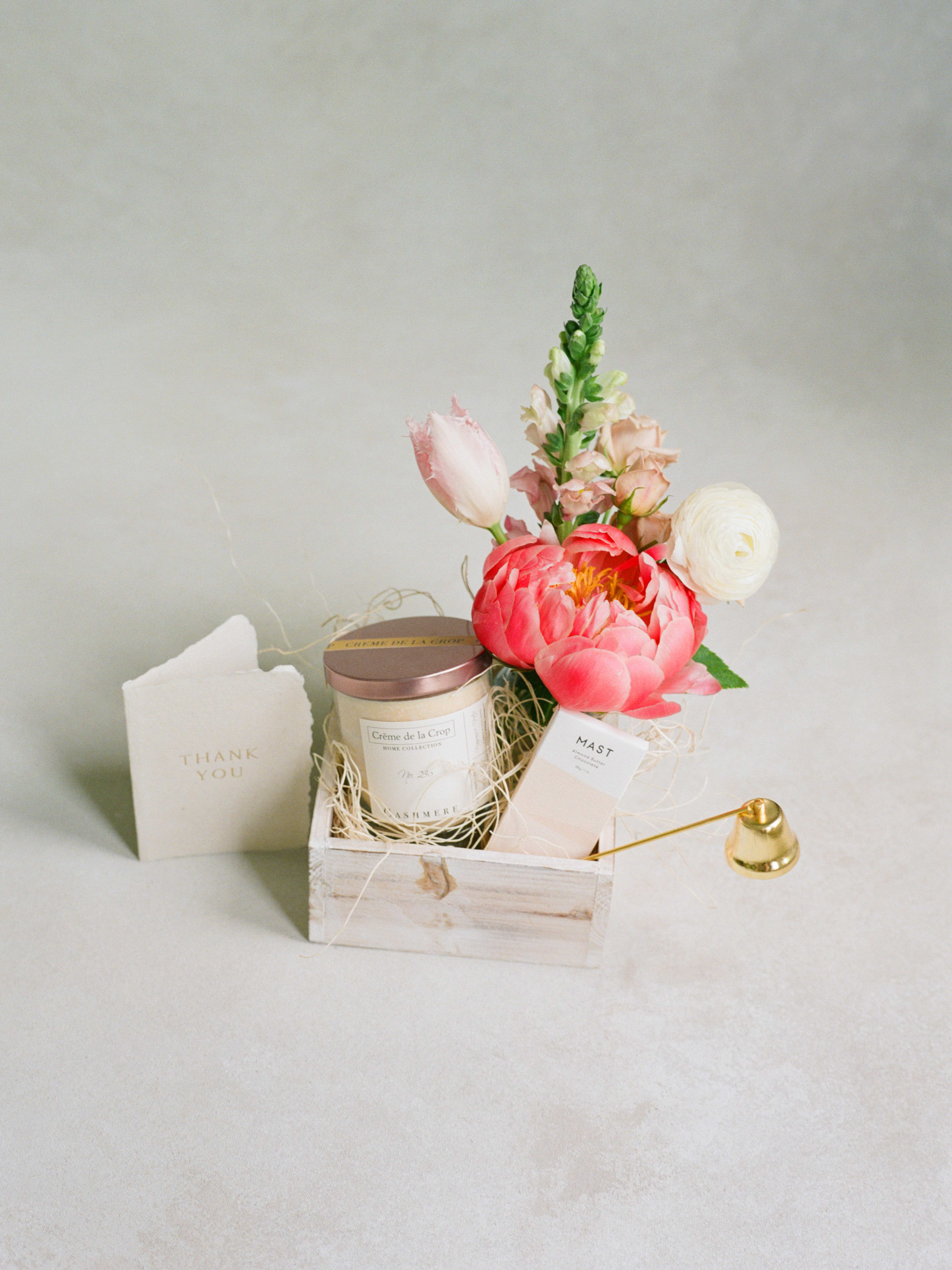 Gift basket with flowers, a candle, and a thank-you card