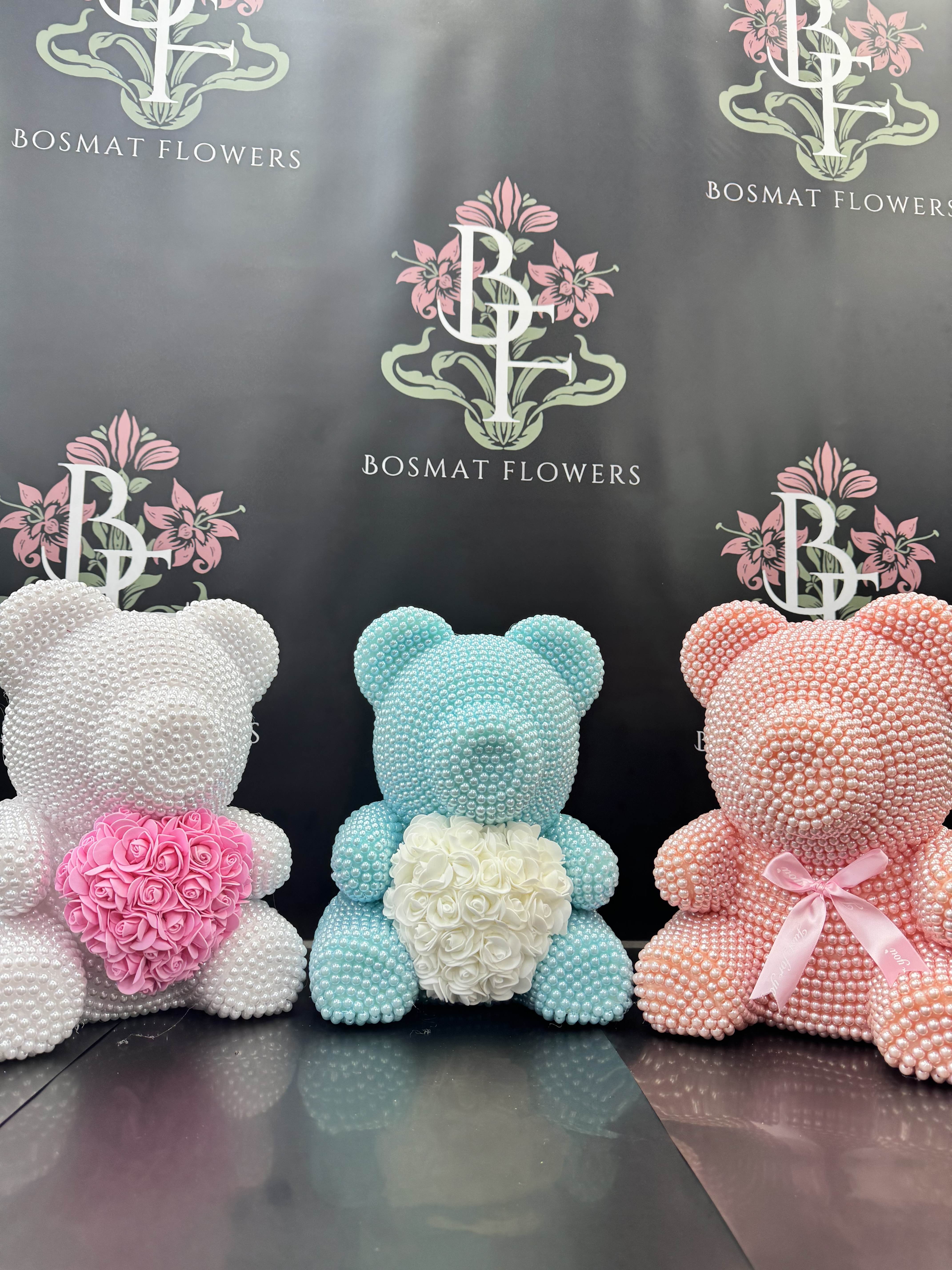 Three pearl-covered teddy bears with floral hearts in pink, white, and blue.
