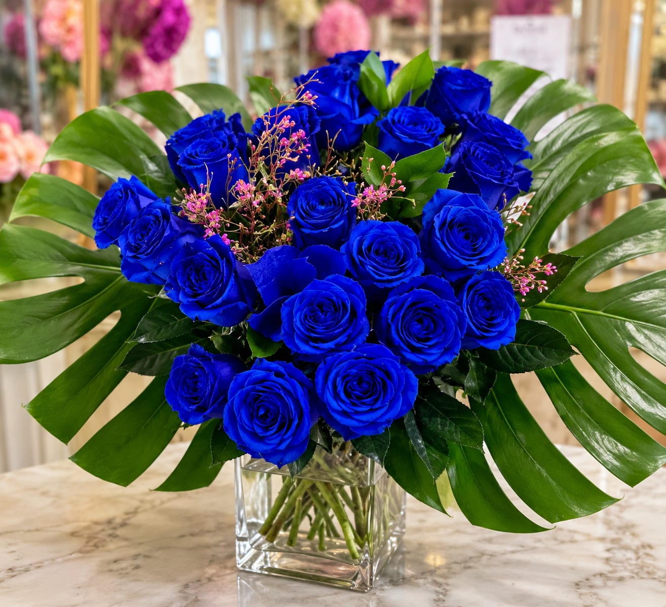 The Majestic Blue Rose Bouquet - These brilliant Blue-Tinted roses are hand dyed with a classic technique, perfected over time. Your sweetheart is sure to be stunned by this thoughtful and one of a kind gift! Perfect way to say Congratulations on your new Baby Boy, or simply for a Friends Birthday!   Flowers are delivered arranged and wrapped in a gift wrapping paper. Roses may take 2-3 days to open up as shown in product photo. Upon arrival, remove flowers from wrap, trim ends of stems, and place them in a vase with water, and enjoy your beautiful bouquet!  20 long stem fresh Blue-Tinted Roses, 1 stem of Oriental Lily/Calla Lily, bunch of Lemon Leaves, Baby's Breath, 3 stem Myrtle Branch/Bells of Ireland, 2 Monstera/Elephant Ear Leaves.