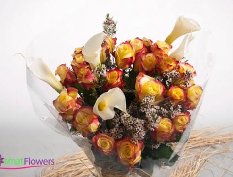 Bouquet of yellow and red roses with white calla lilies
