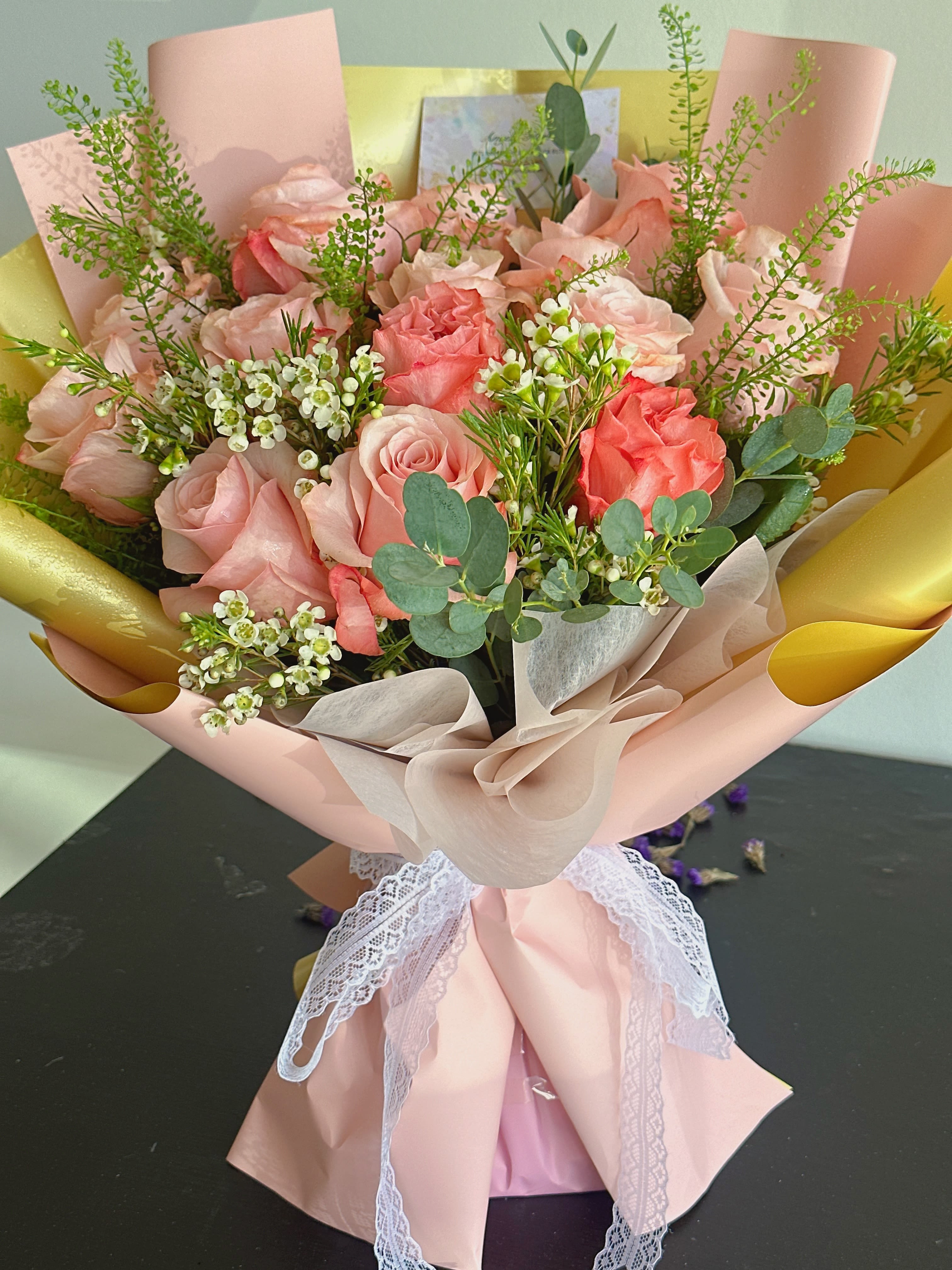 Pink rose bouquet wrapped in blush paper with lace ribbon