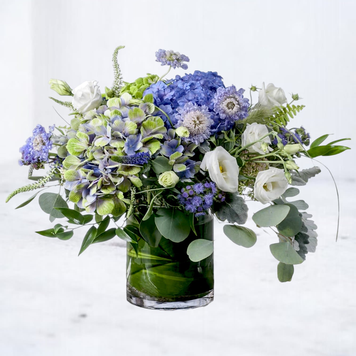 Blue and white floral arrangement in a glass vase