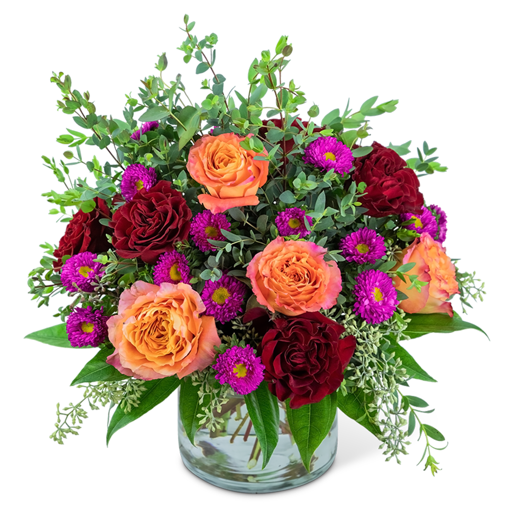 Orange and red roses with purple daisies in a glass vase