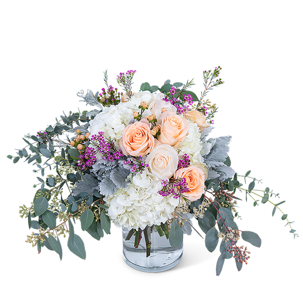Peach roses and white hydrangeas in a clear glass vase
